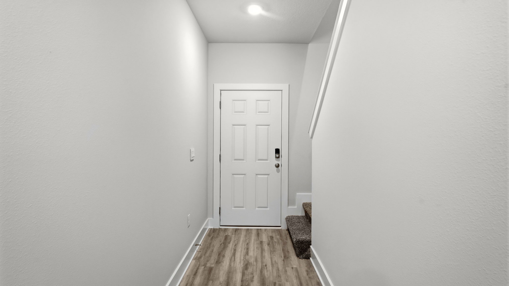 Front entrance hallway with EVP flooring next to carpeted stairs.