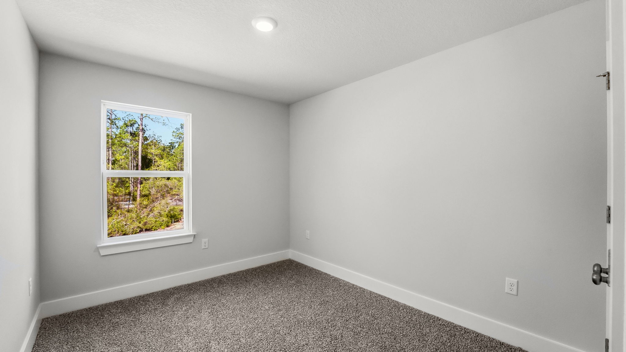 Bedroom with carpet flooring and closet and window.