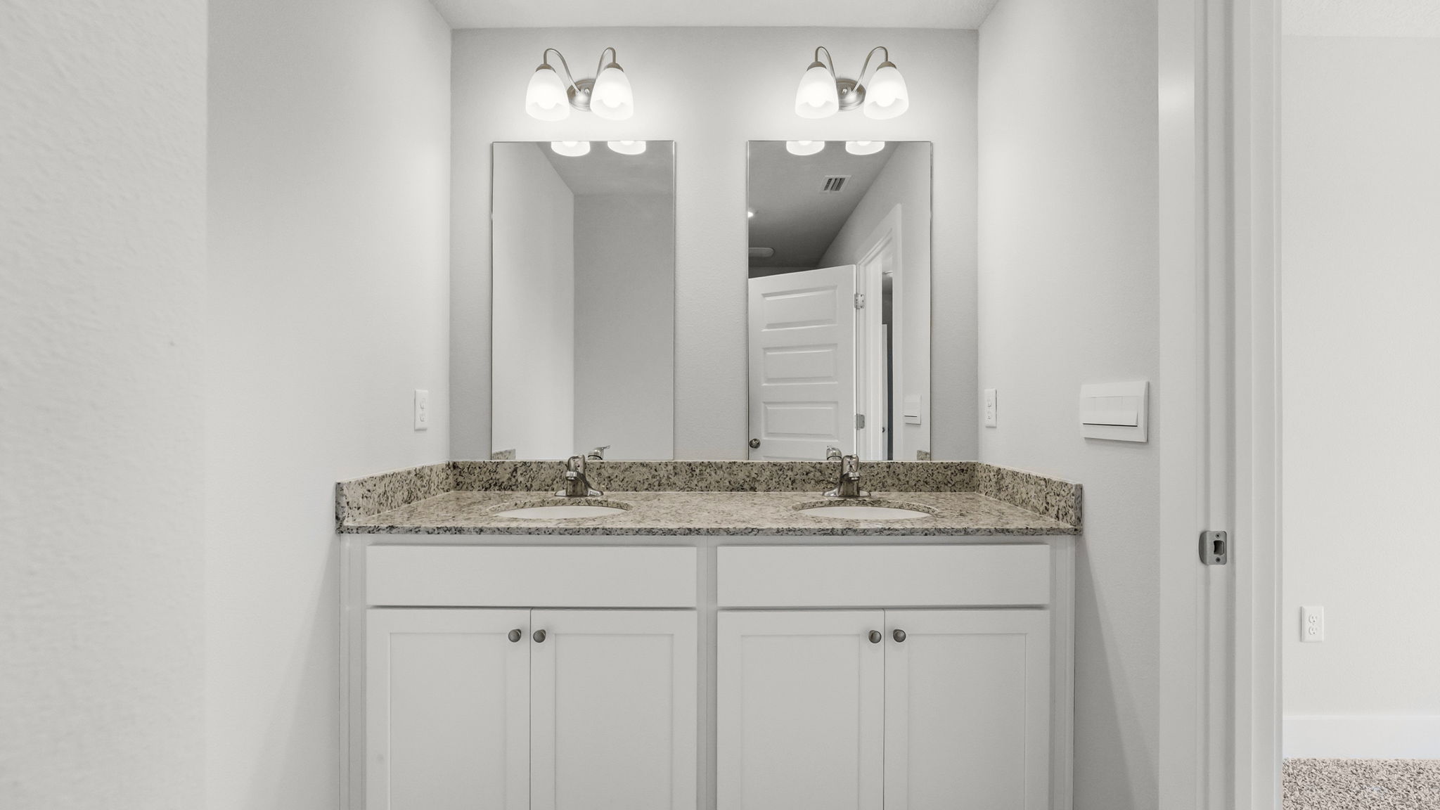 Bathroom with granite countertops and double vanity.