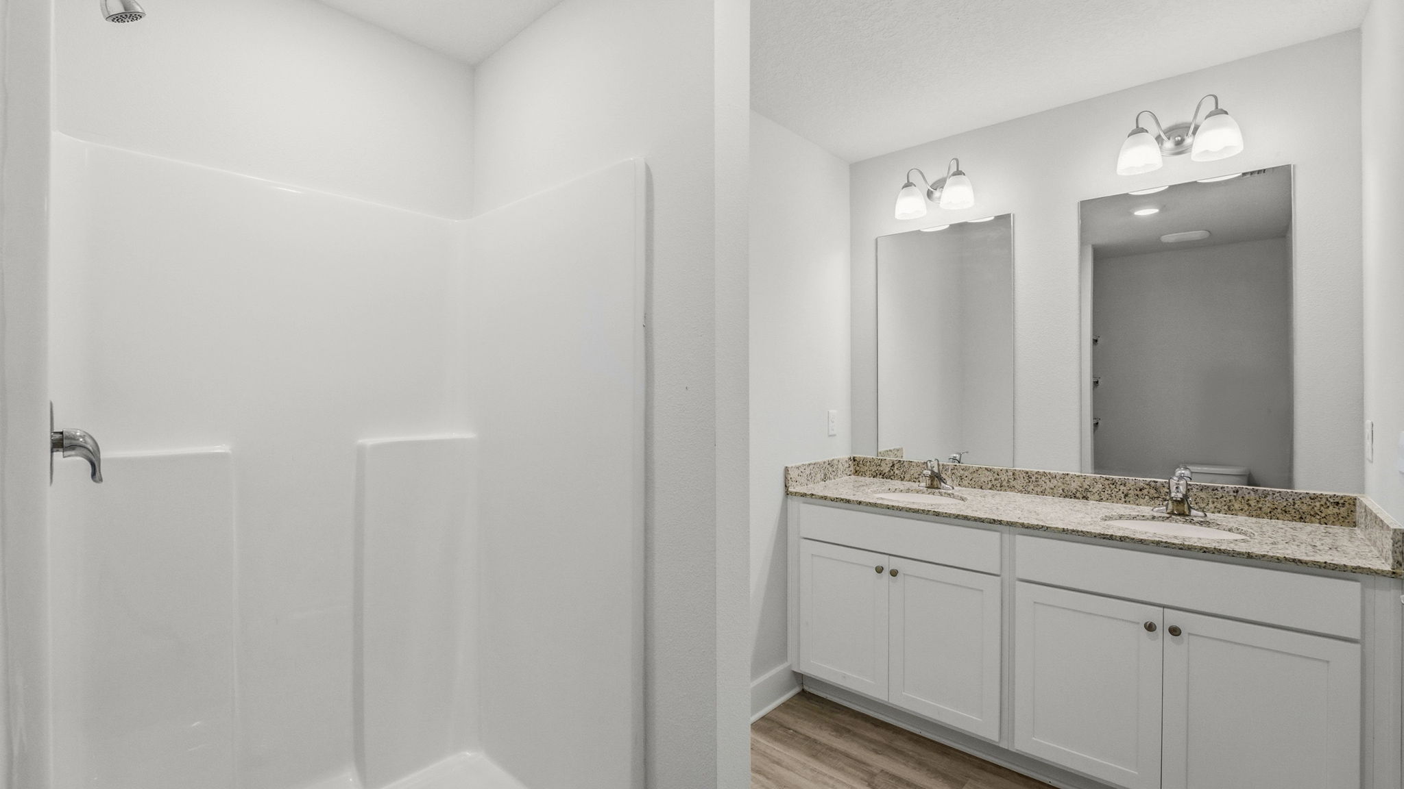 Bathroom with granite countertops and double vanity and shower.