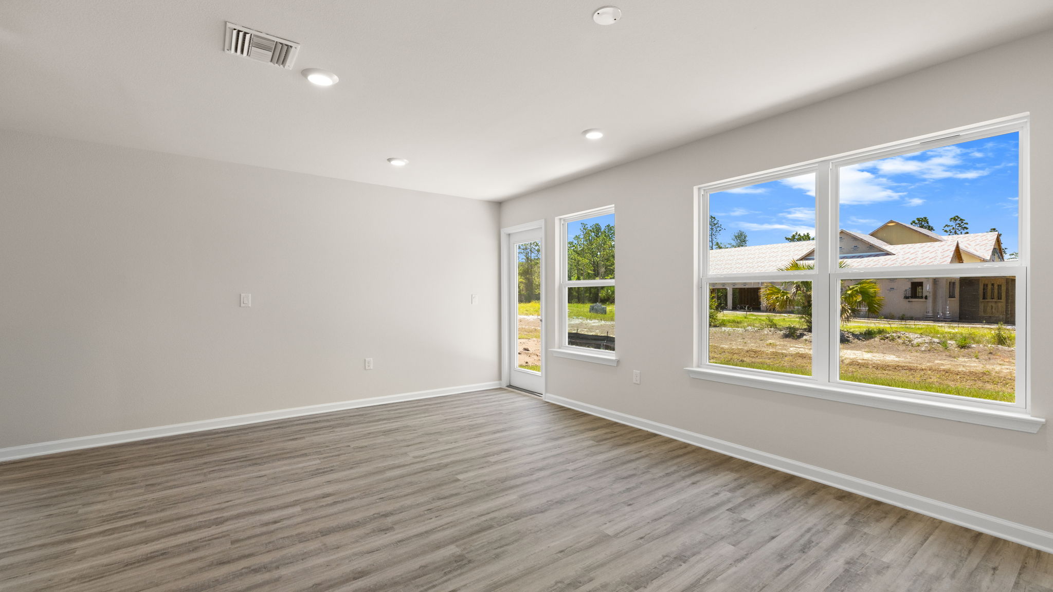 Living room with EVP flooring and windows and back door.