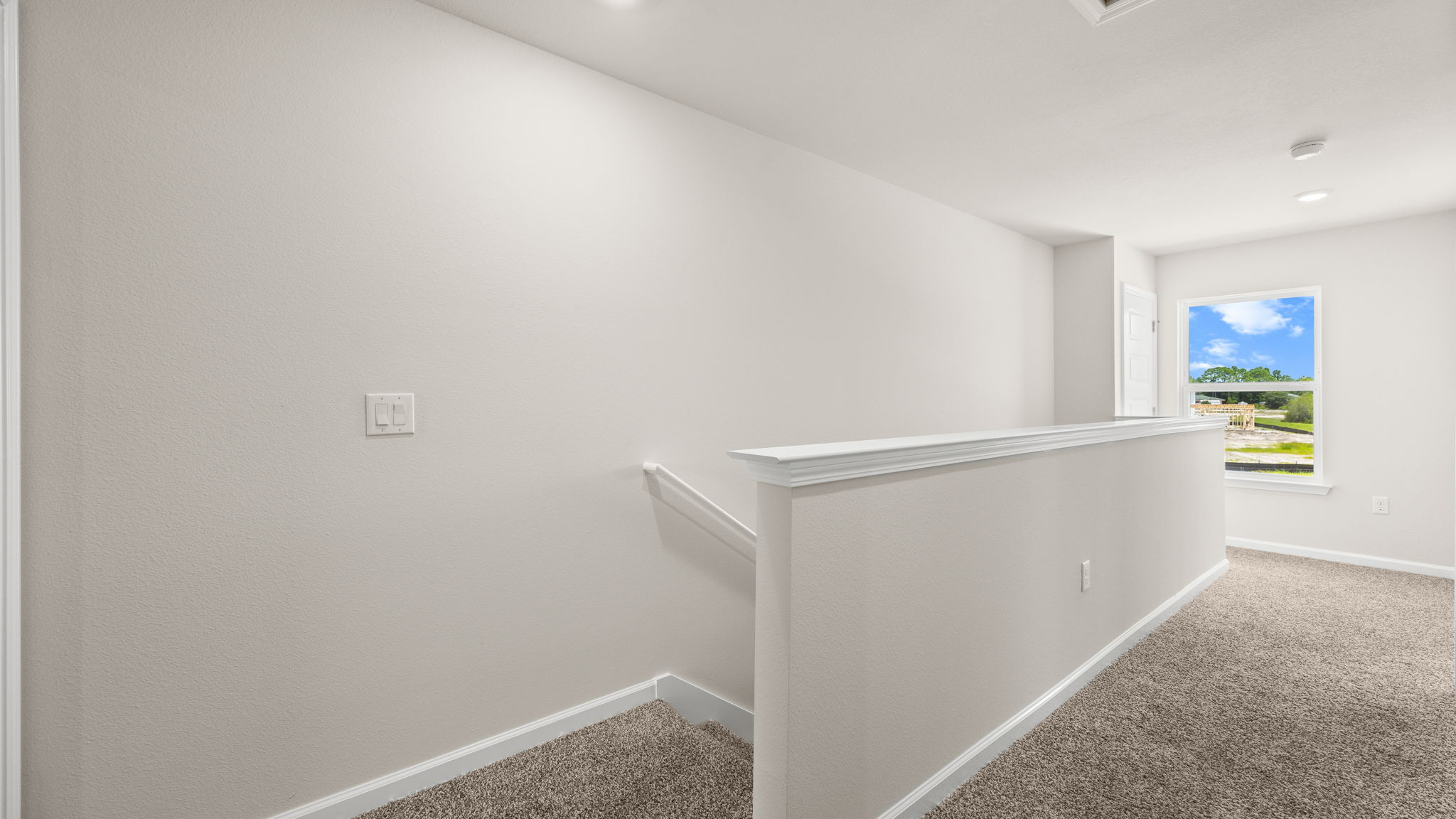 Upstairs hallway next to stairs and bedrooms and laundry room.