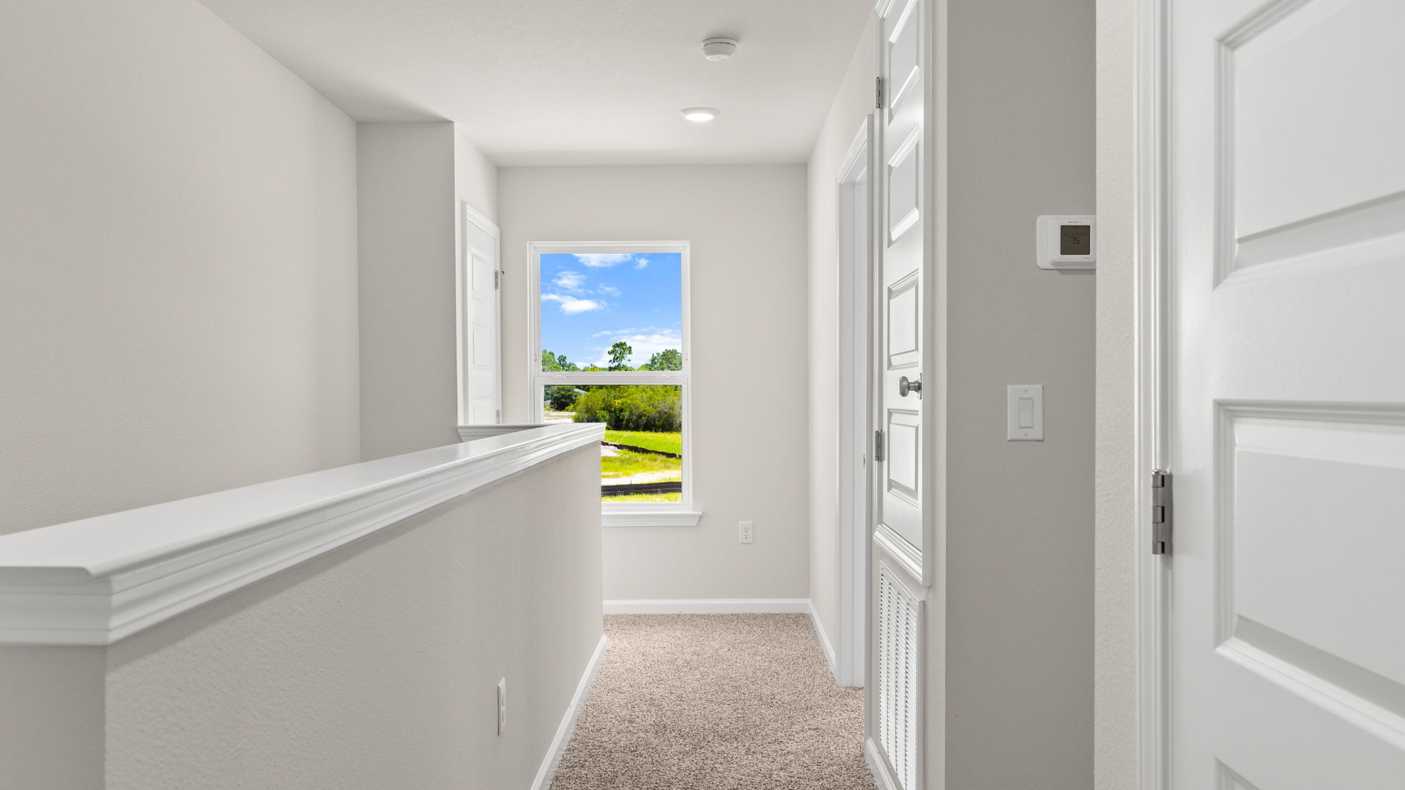 Upstairs hallway next to stairs and bedrooms and laundry room.