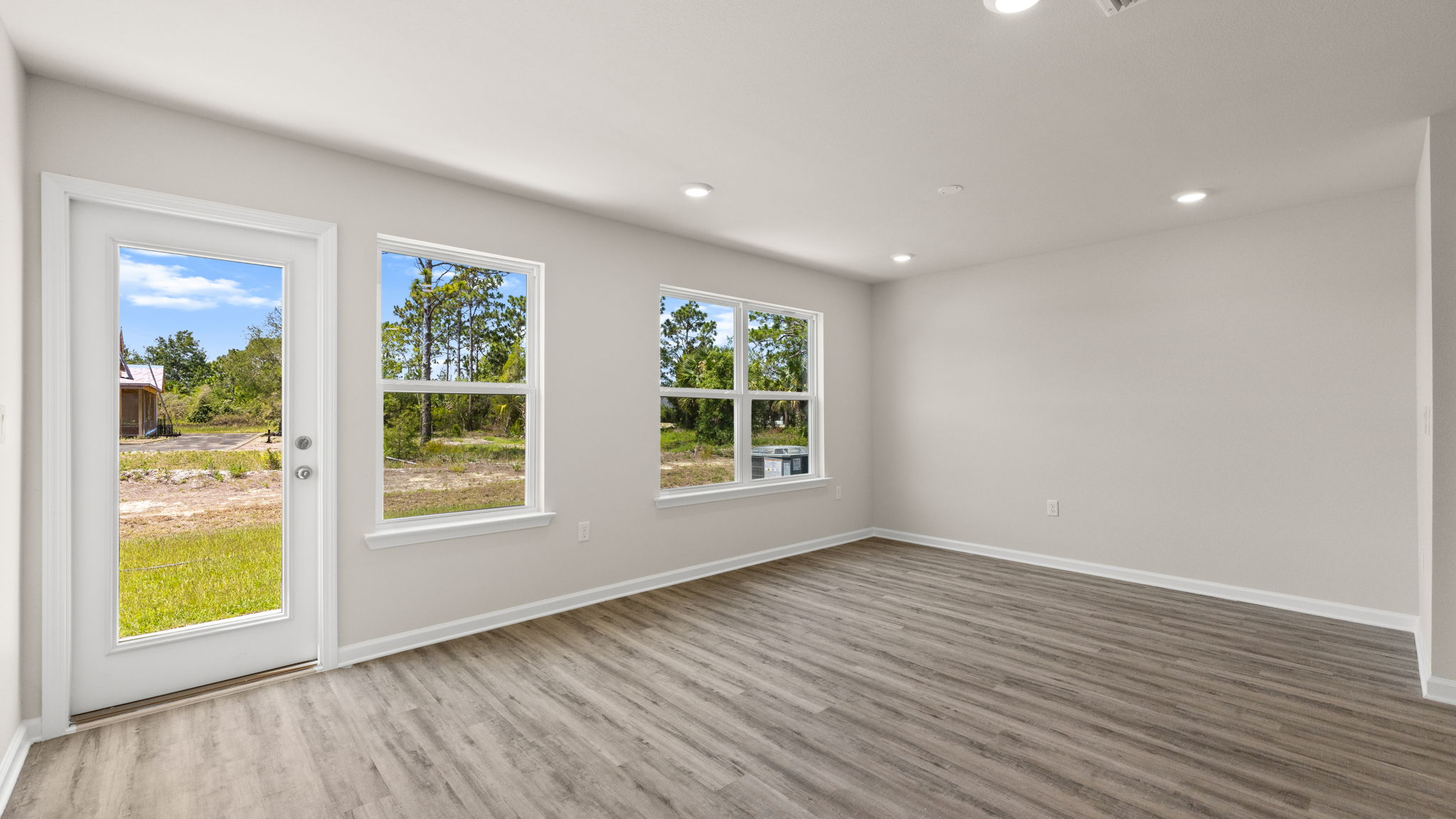 Living room with EVP flooring and windows and back door.