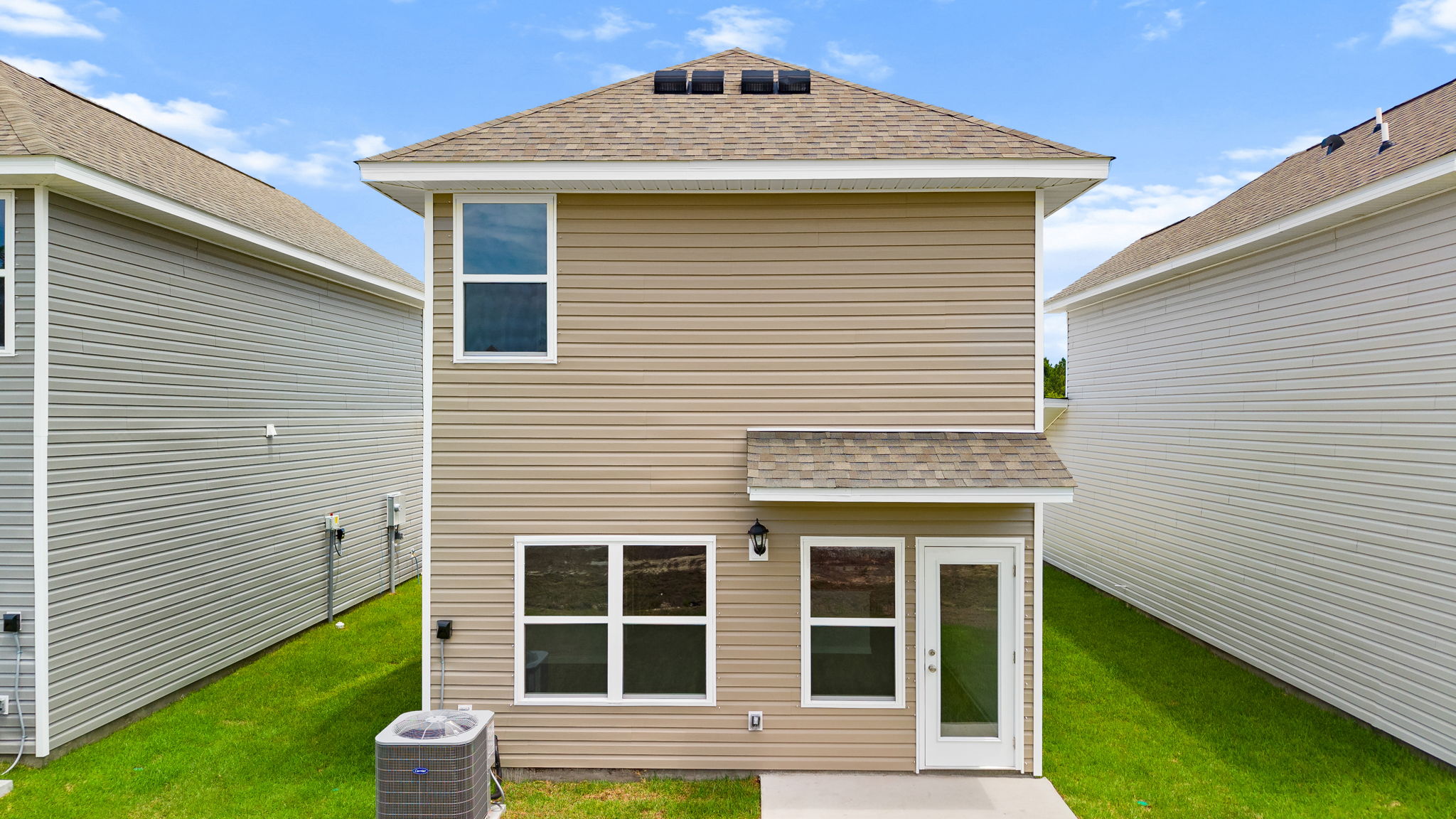 Alderbrook plan rear of home with vinyl siding and back patio.