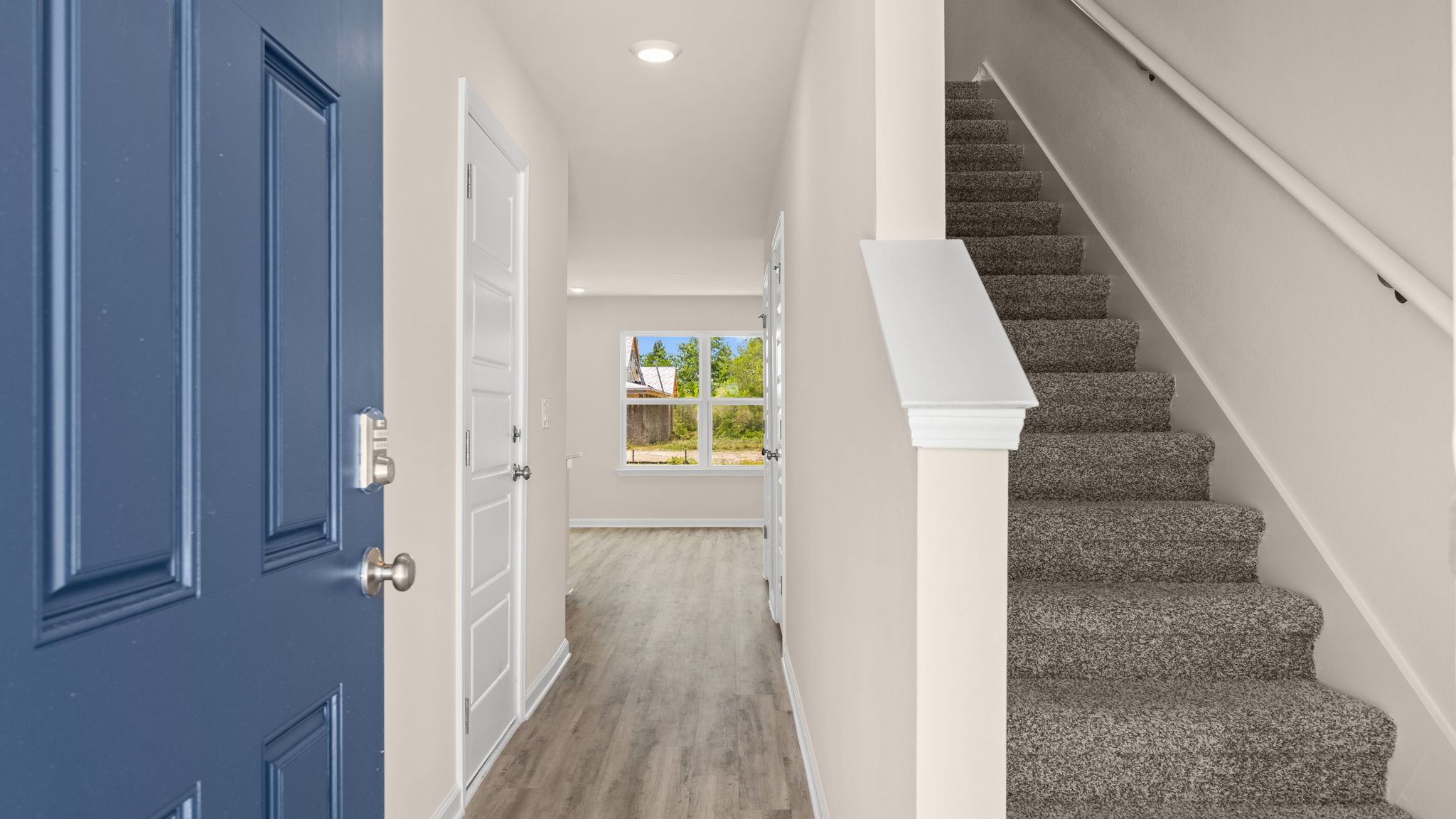 Front entrance hallway with EVP flooring next to carpeted stairs.