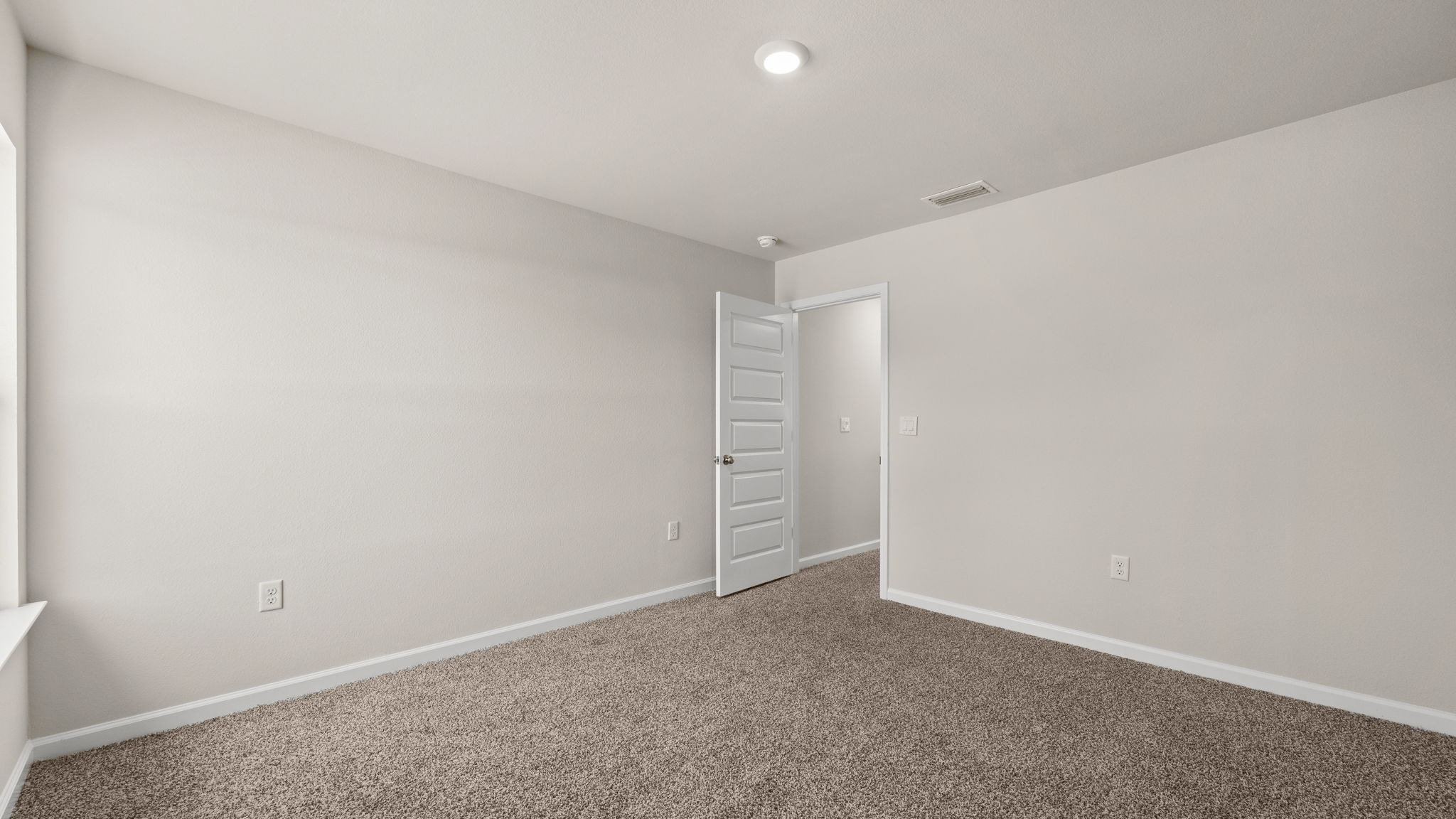 Primary bedroom with carpet floor and hallway entrance.