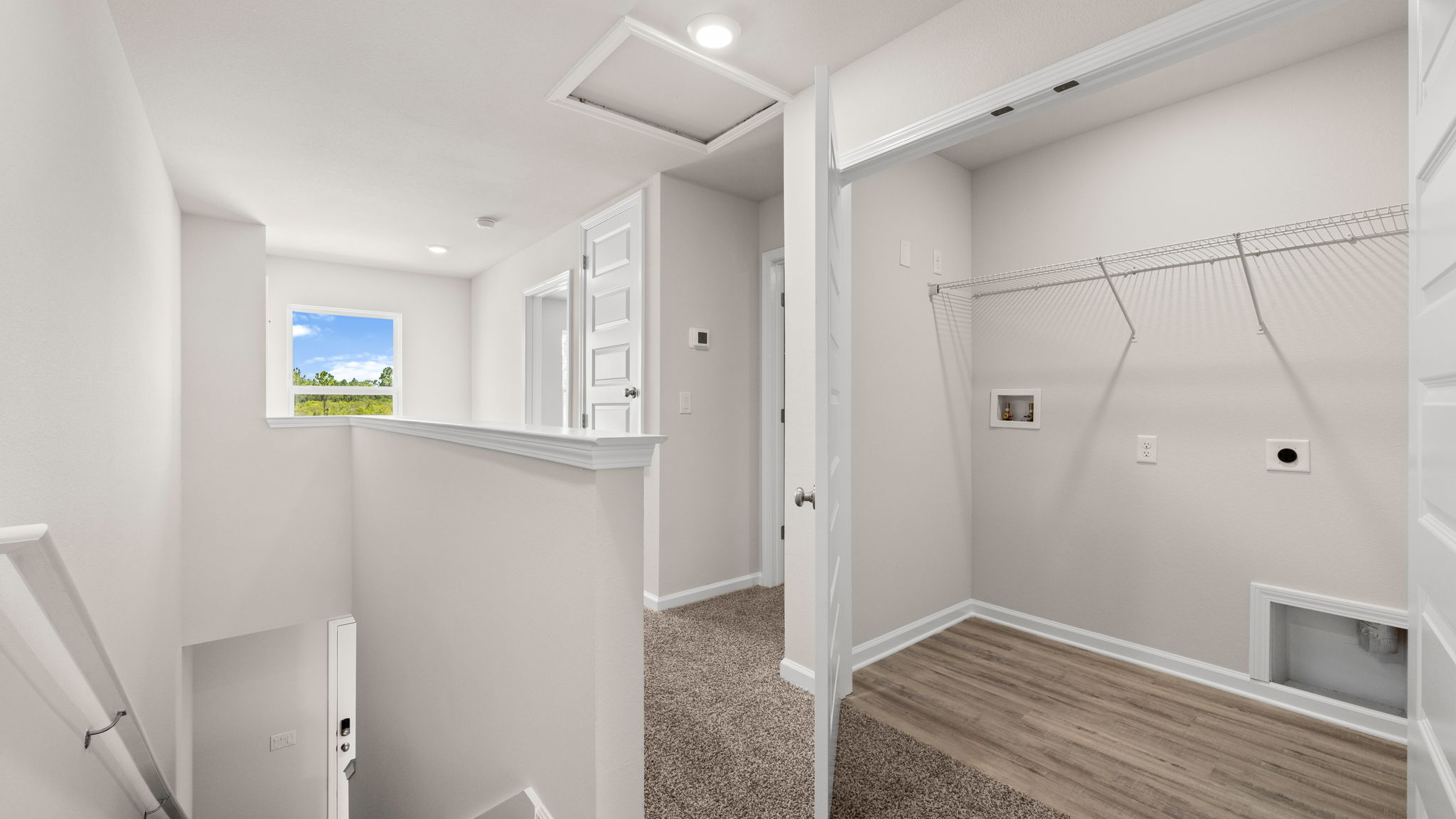 Upstairs hallway next to stairs and bedrooms and laundry room.