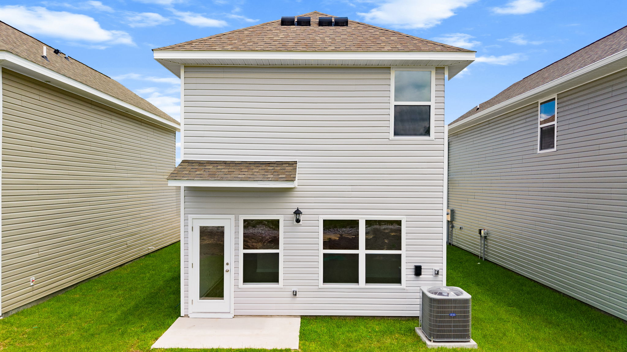 Alderbrook plan rear of home with vinyl siding and back patio.