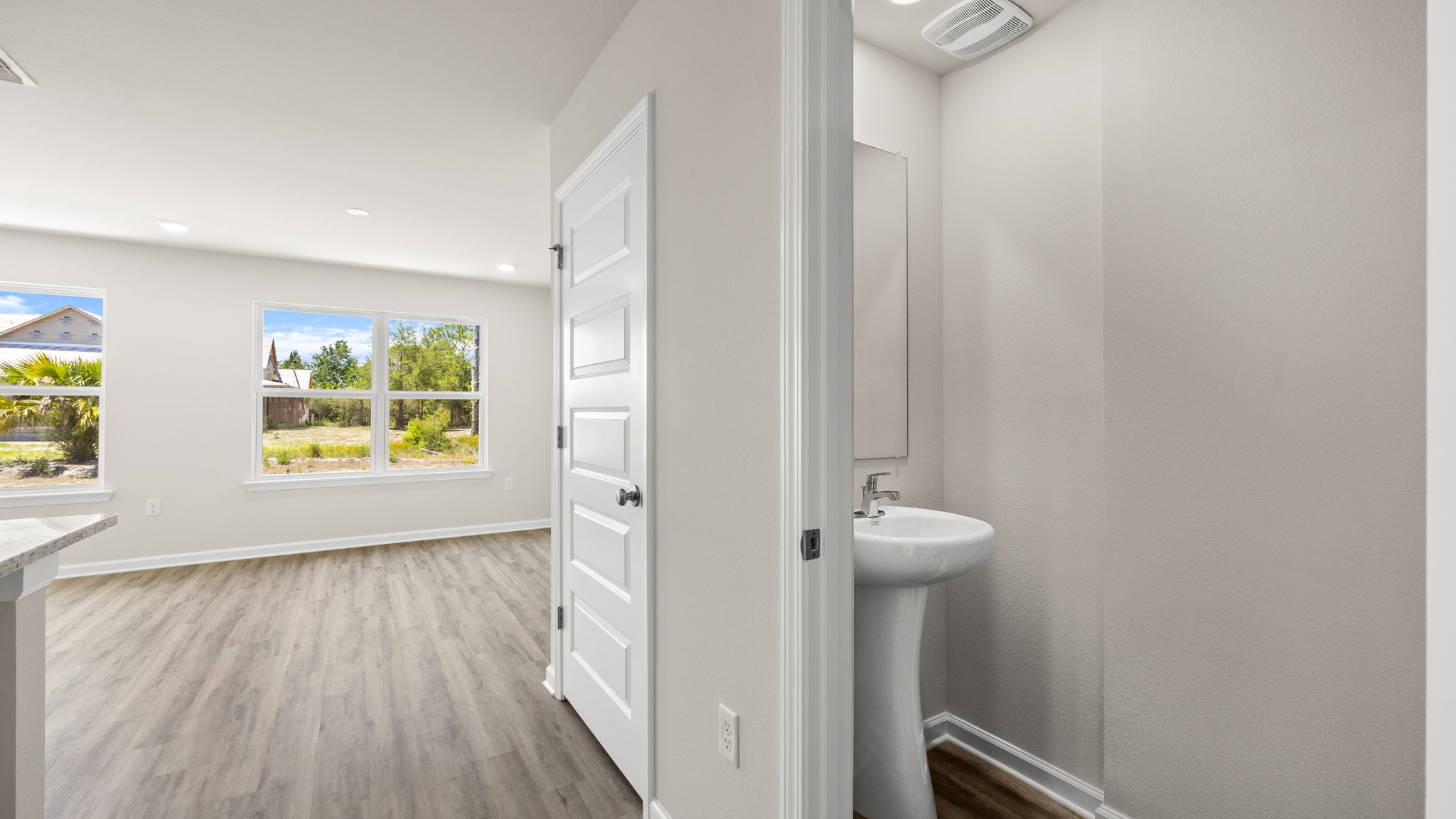Half bathroom next to garage door.