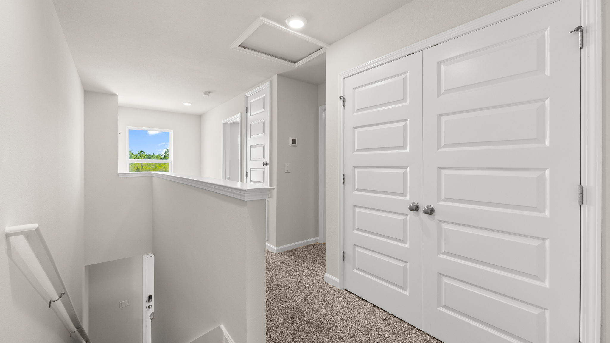 Upstairs hallway next to stairs and bedrooms and laundry room.