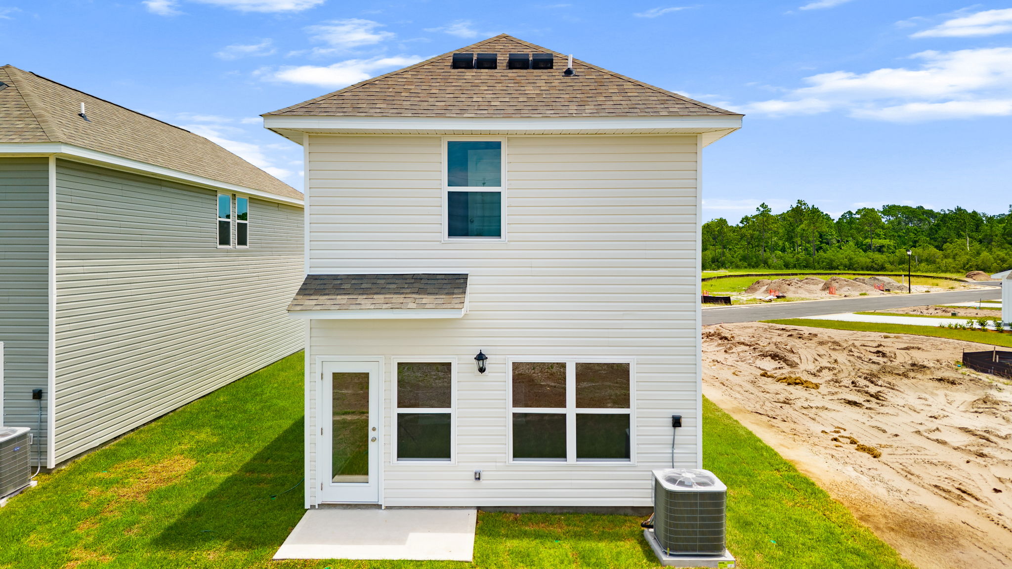 Bandon plan rear of home with vinyl siding and back patio.