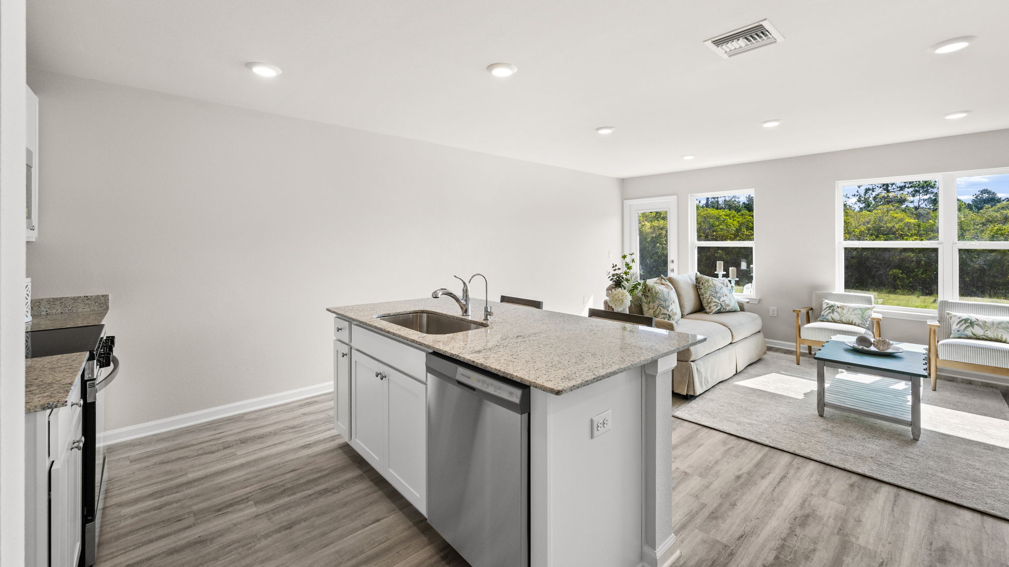 Open living room view and kitchen with kitchen island.
