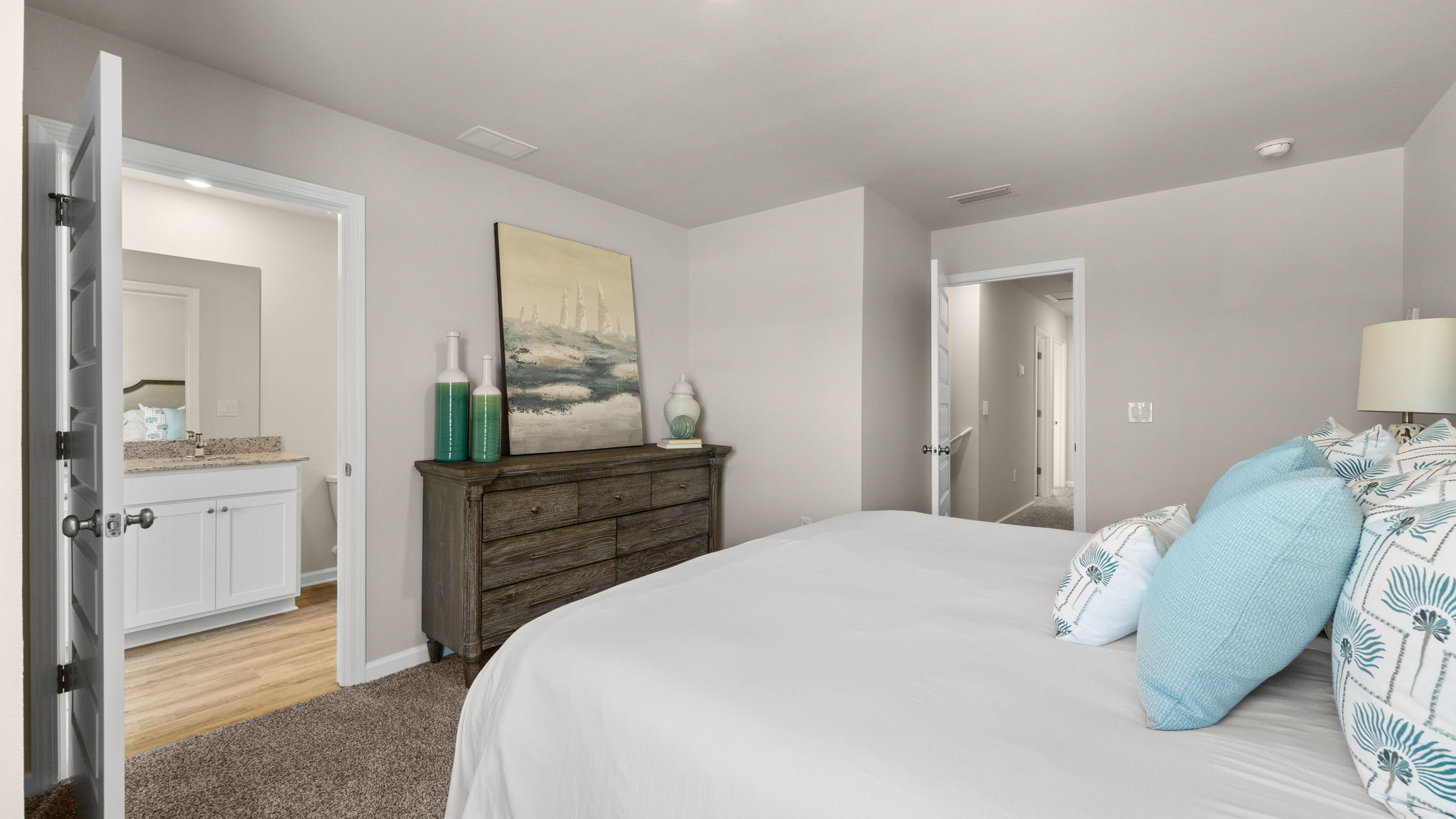 Primary bedroom with carpet floor and bathroom entrance.