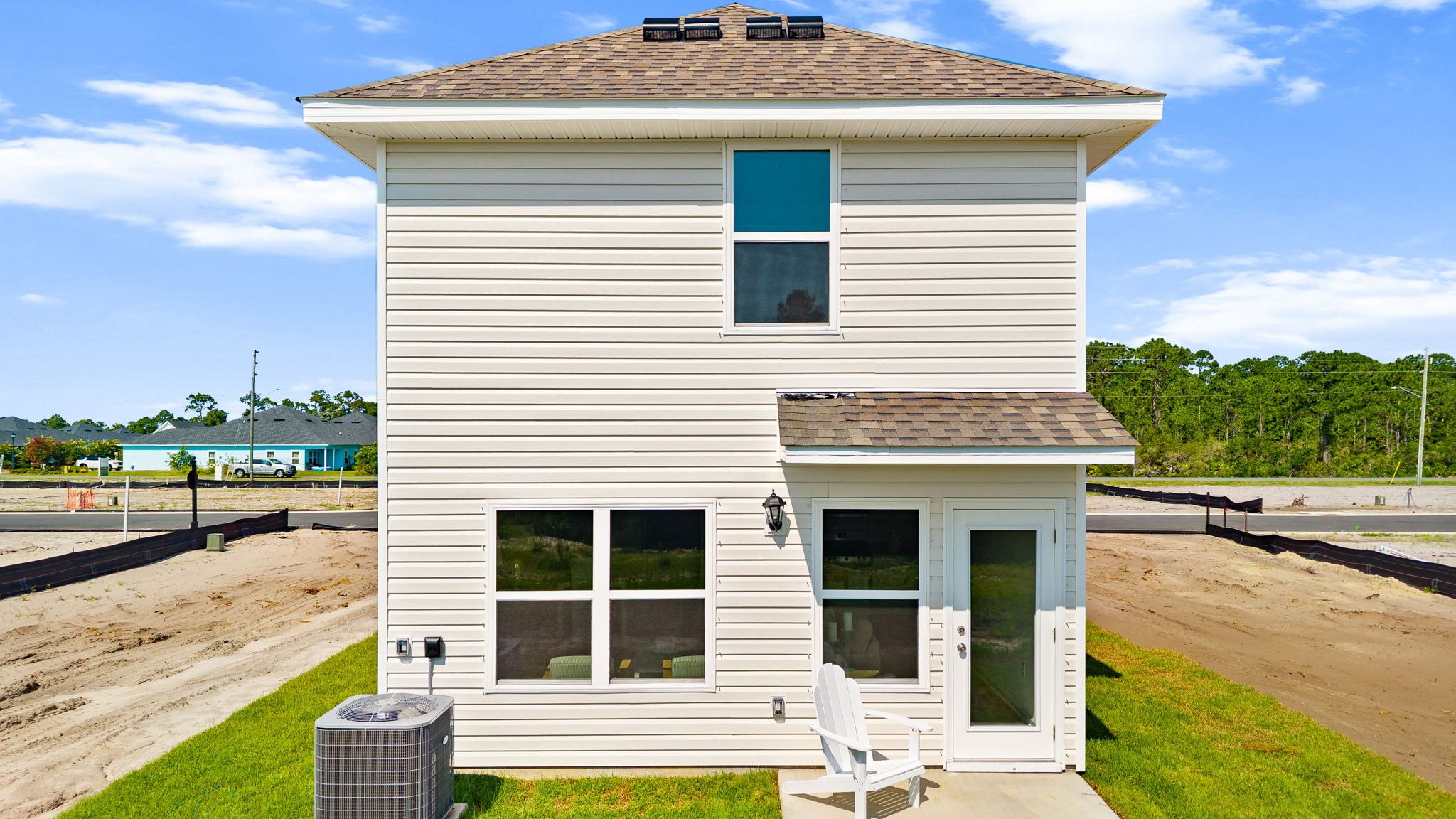 Bandon plan rear of home with vinyl siding and back patio.