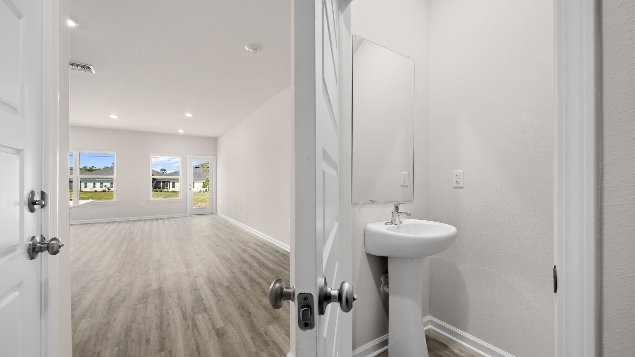 Half bathroom next to garage door.