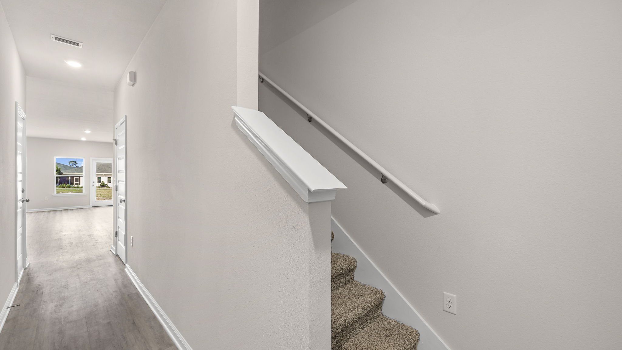 Front entrance hallway with EVP flooring next to carpeted stairs.