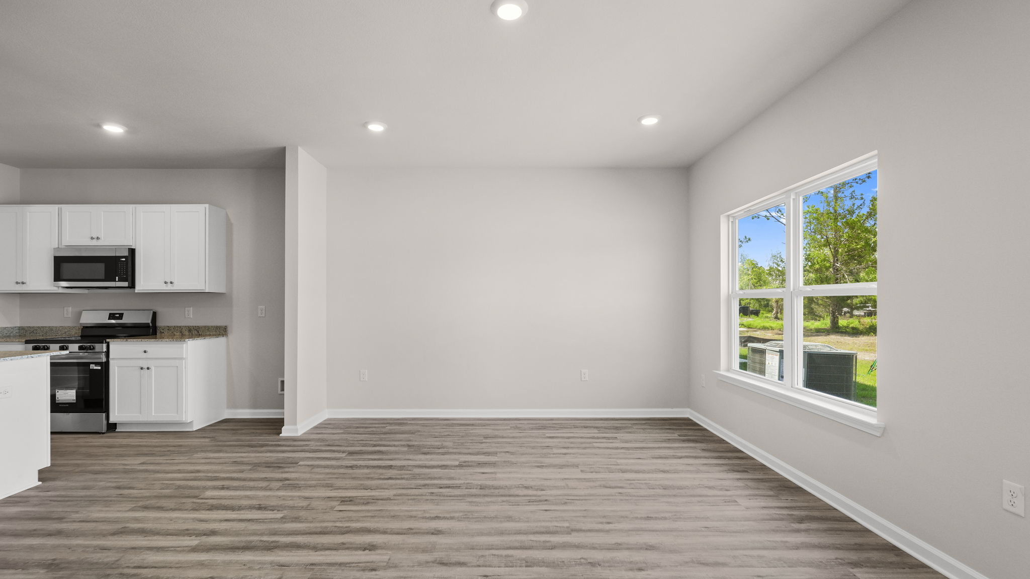 Living room next to kitchen and windows.