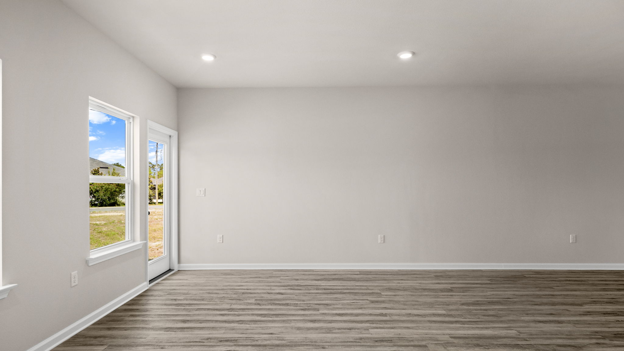 Living room with EVP flooring and windows and back door.