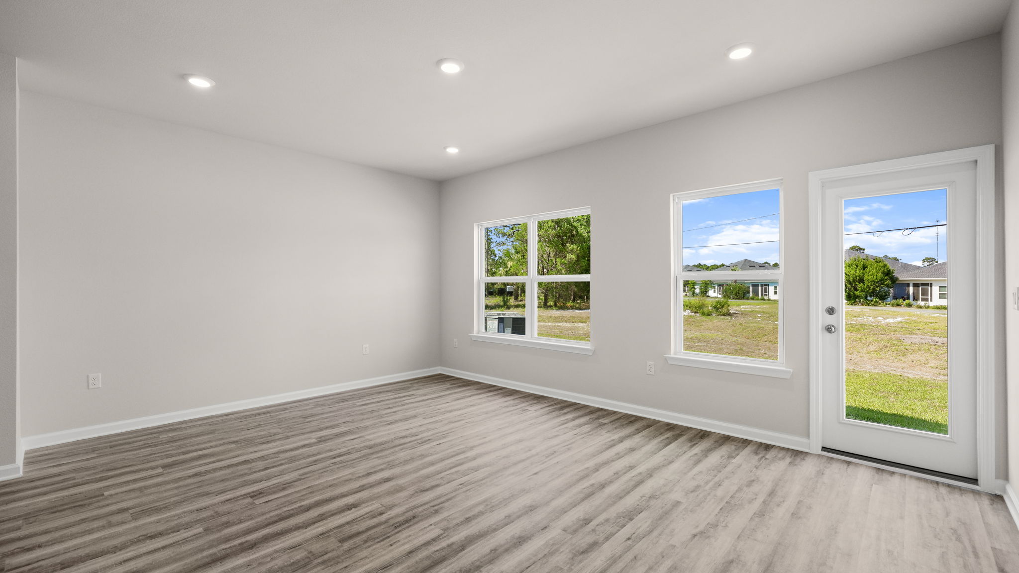 Living room with EVP flooring and windows and back door.