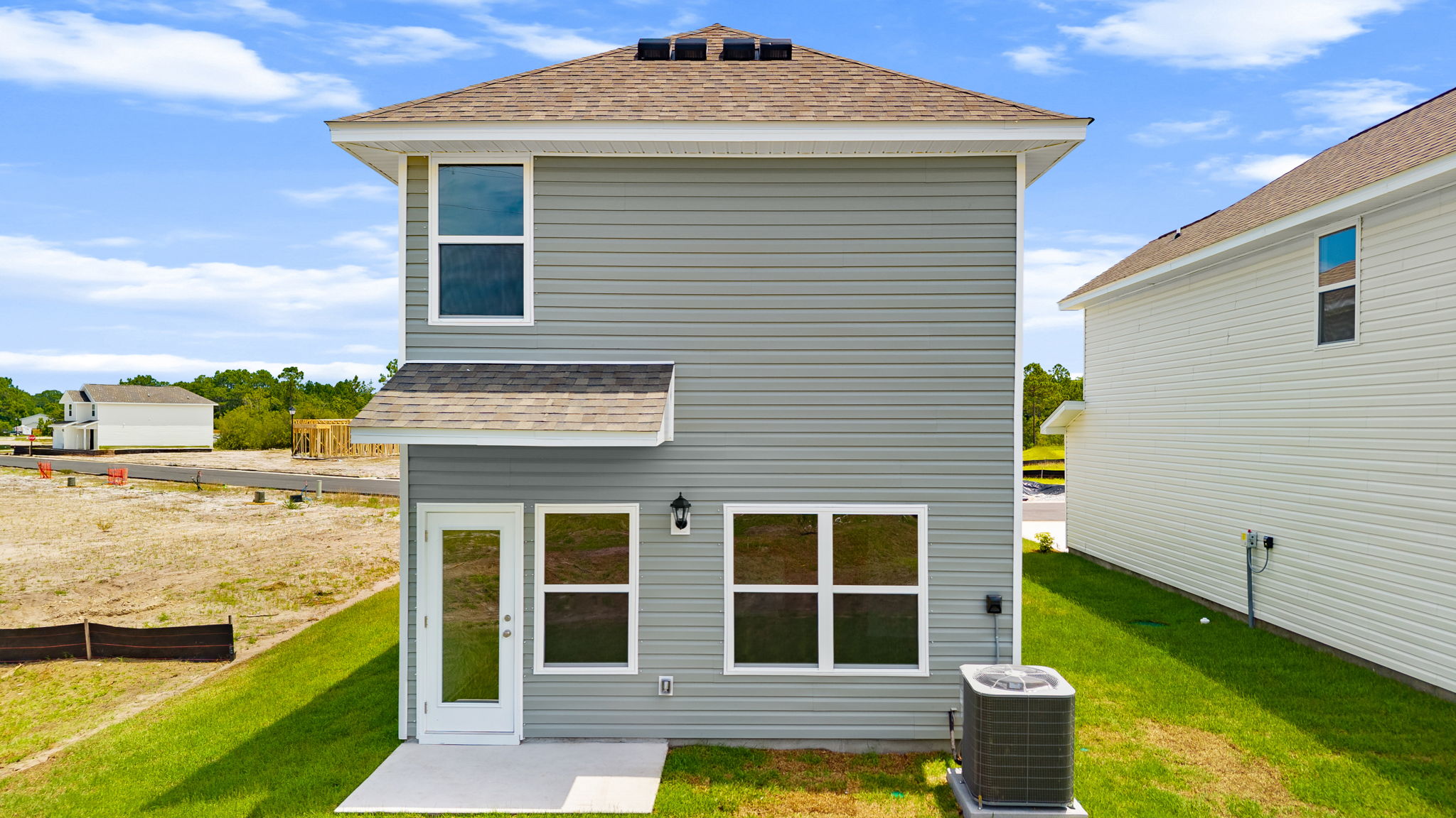 Canmore plan rear of home with vinyl siding and back patio.