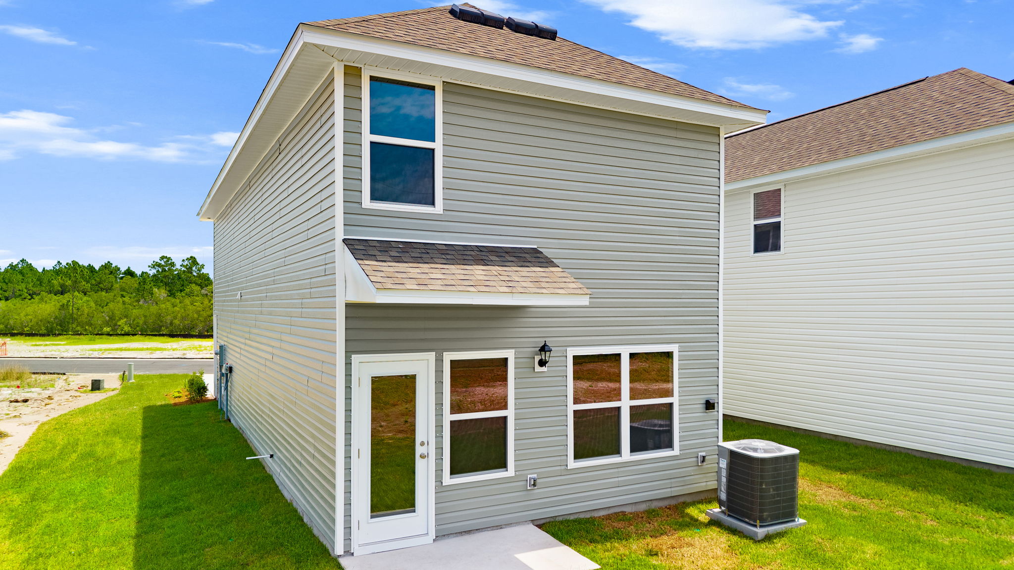 Canmore plan rear of home with vinyl siding and back patio.