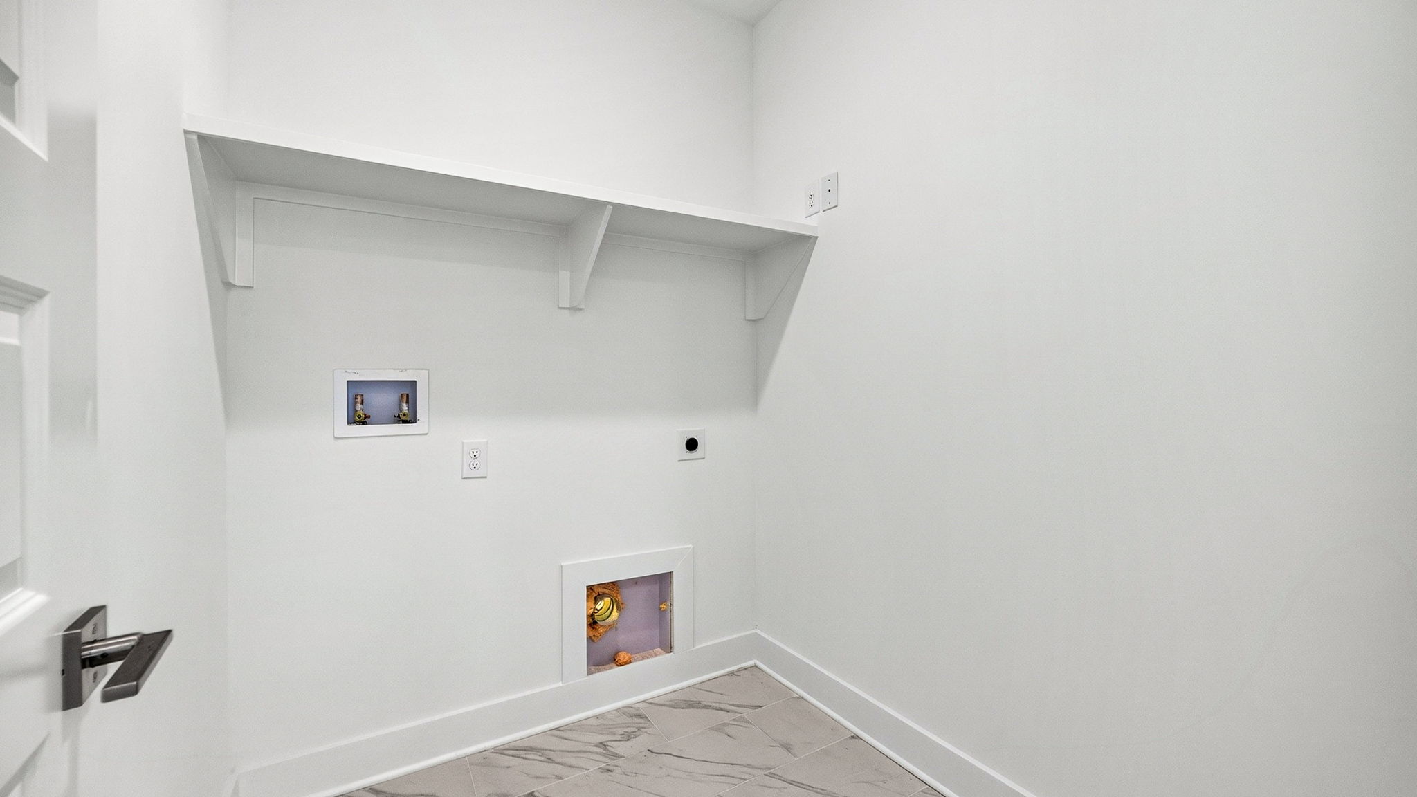 Laundry room with tile flooring and wood shelving.