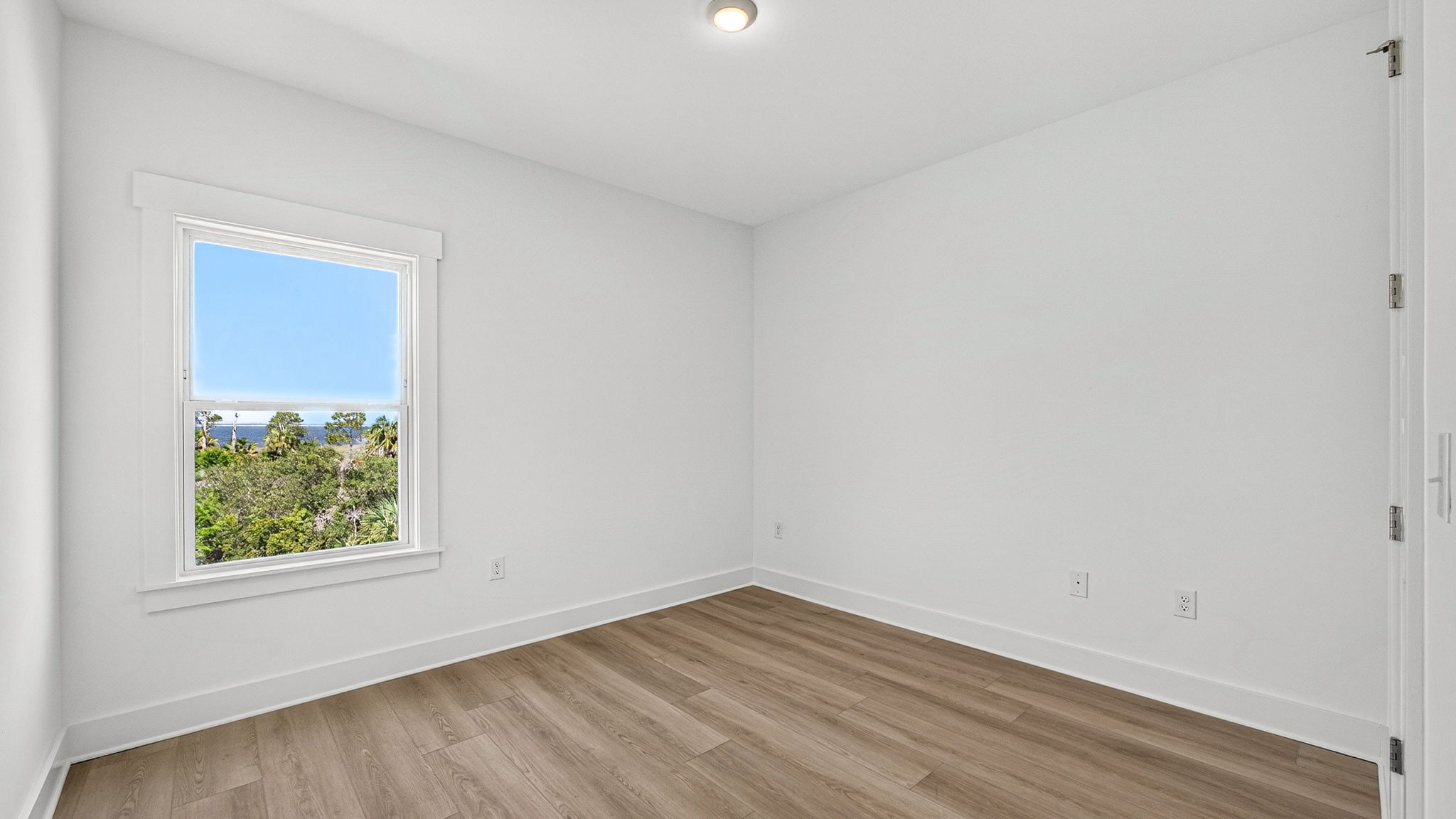 Bedroom with EVP flooring and closet and window.