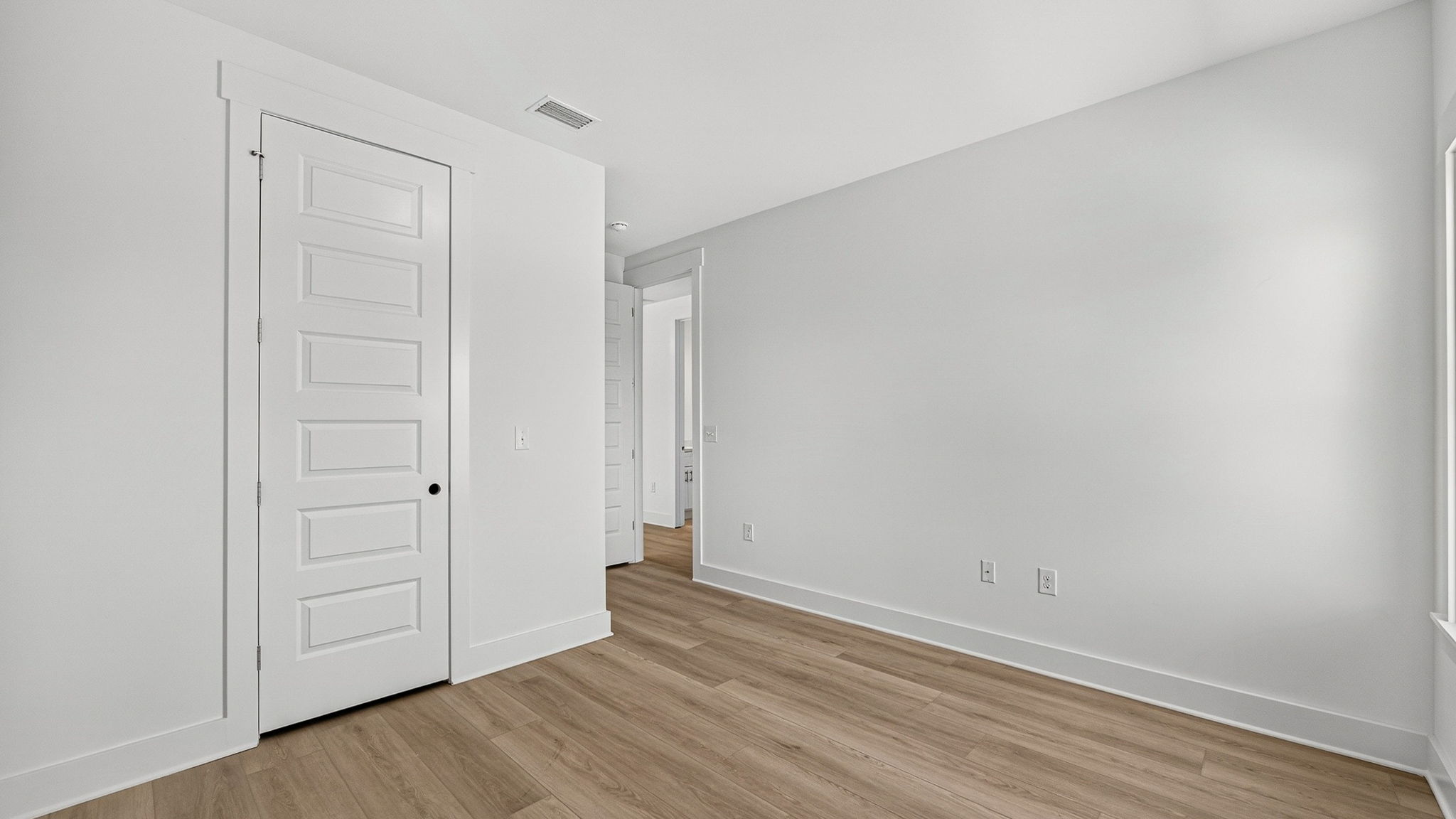 Bedroom with EVP flooring and closet.