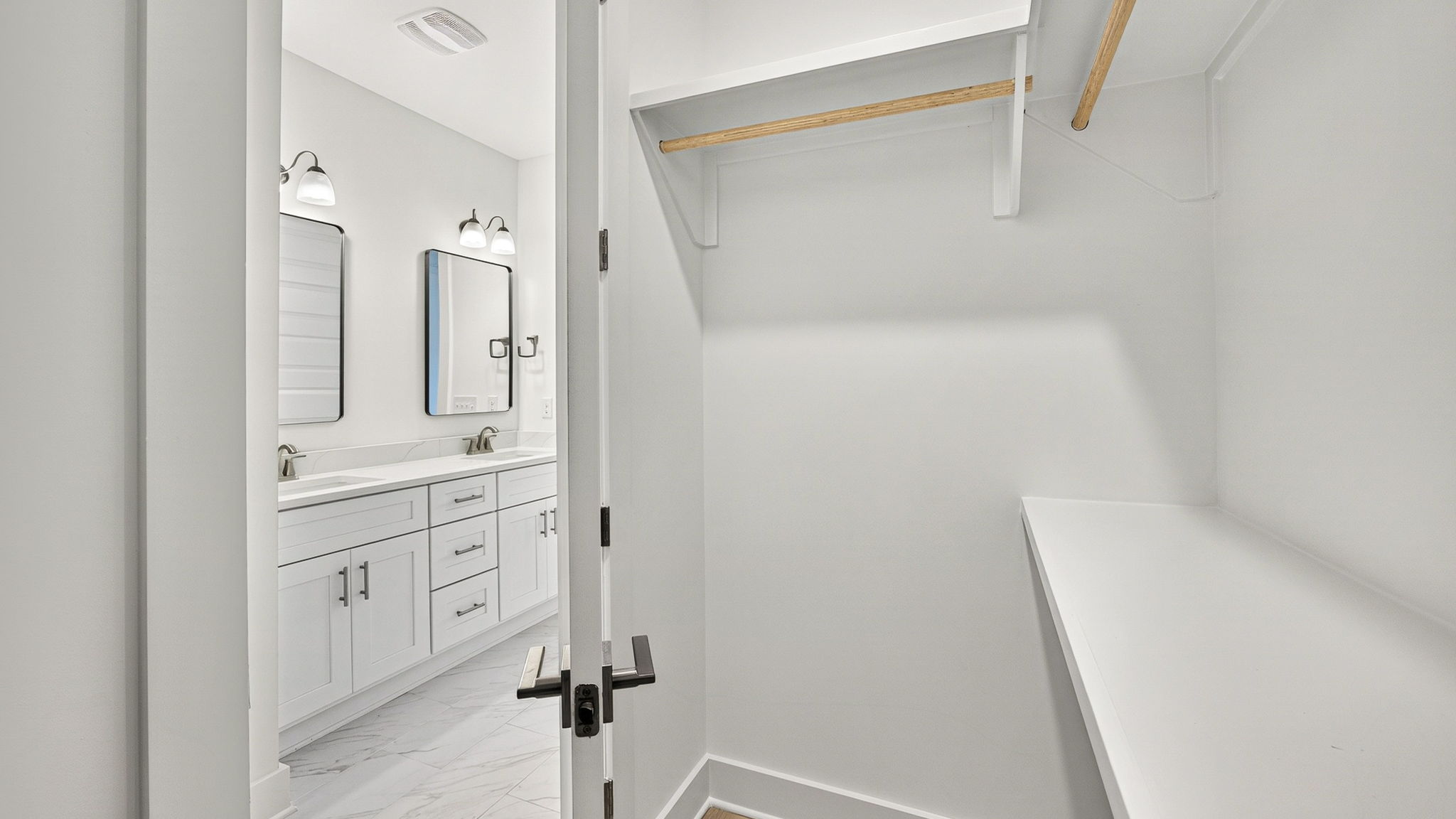 Walk-in closet with wooden shelving in primary bathroom.
