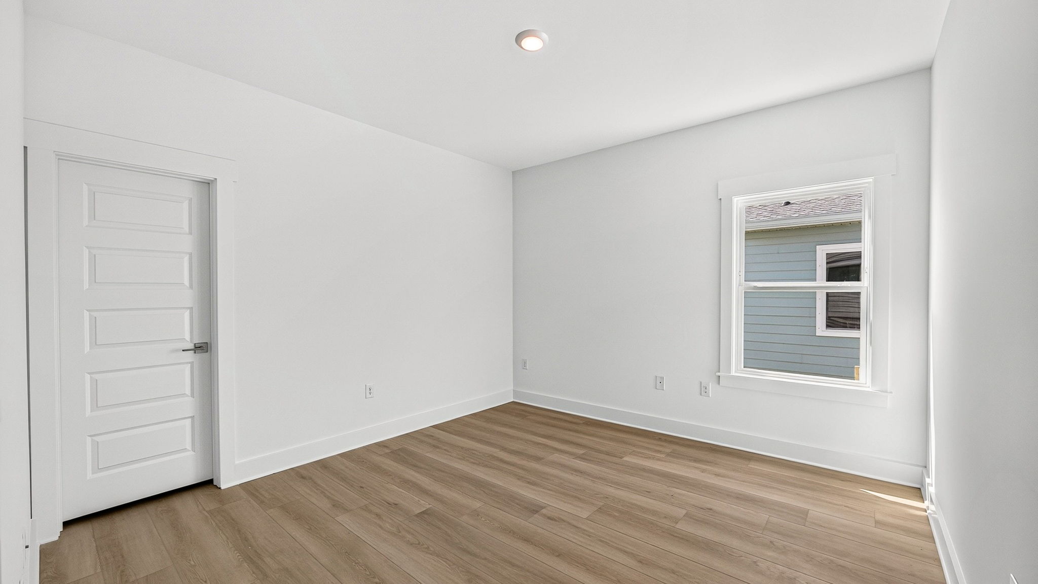 Bedroom with EVP flooring and closet and window.