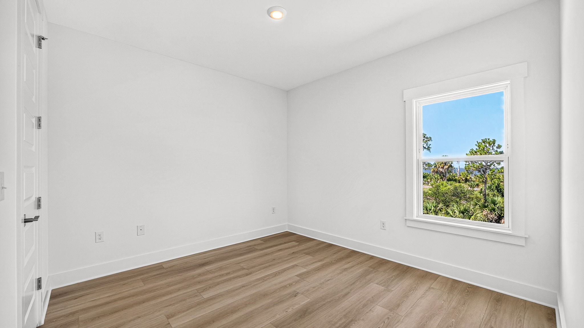 Bedroom with EVP flooring and closet and window.