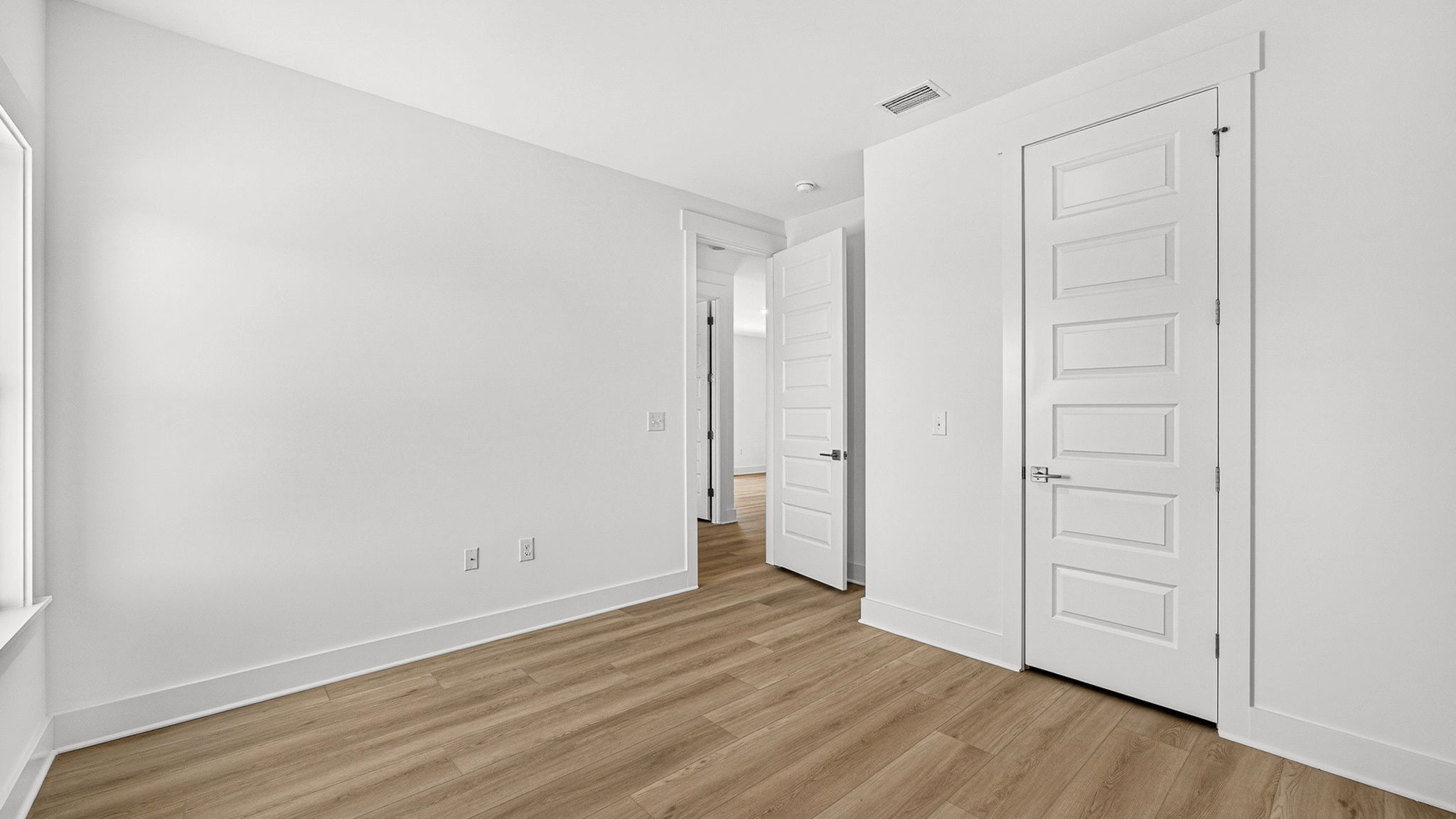 Bedroom with EVP flooring and closet.