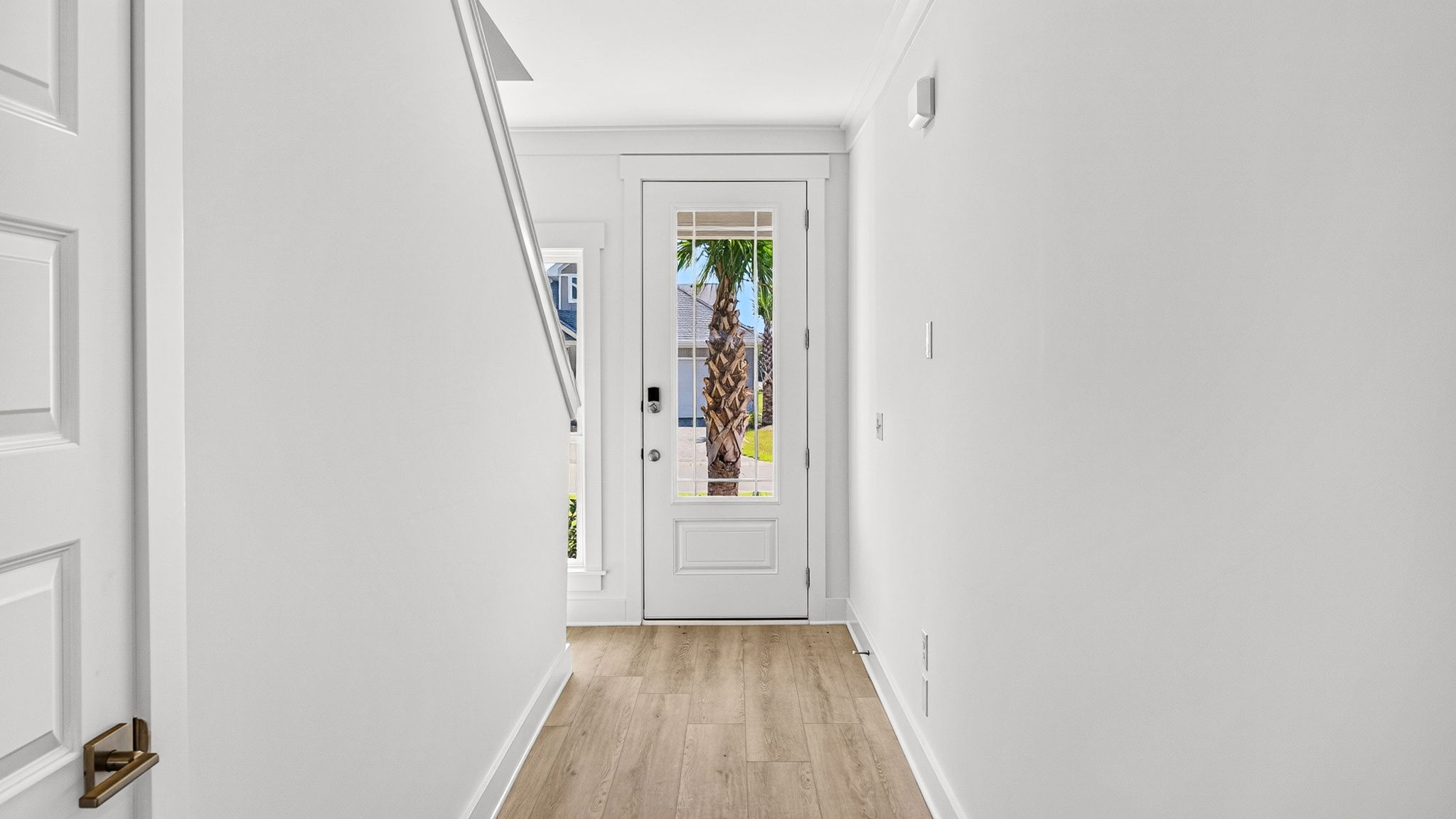 Front entrance hallway with EVP flooring next to wooden stairs.