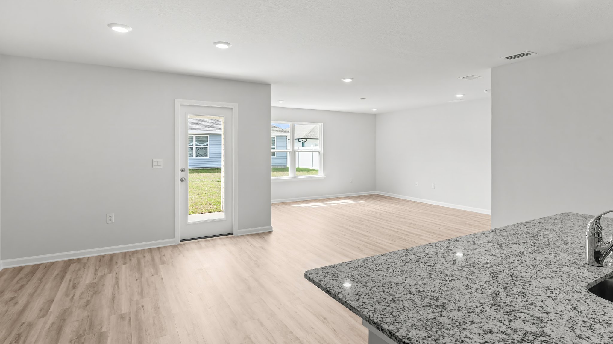 Dining area with EVP flooring and back door next to kitchen.