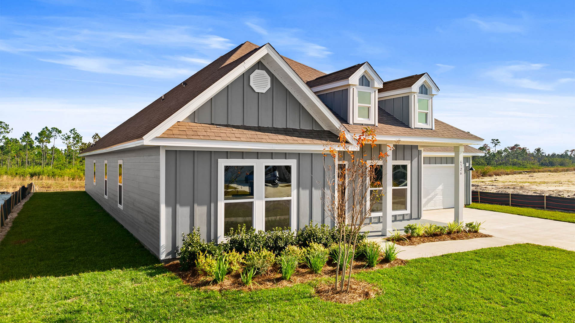 Mckenzie plan at Destini Lane with Hardie siding and covered front porch and two car garage.