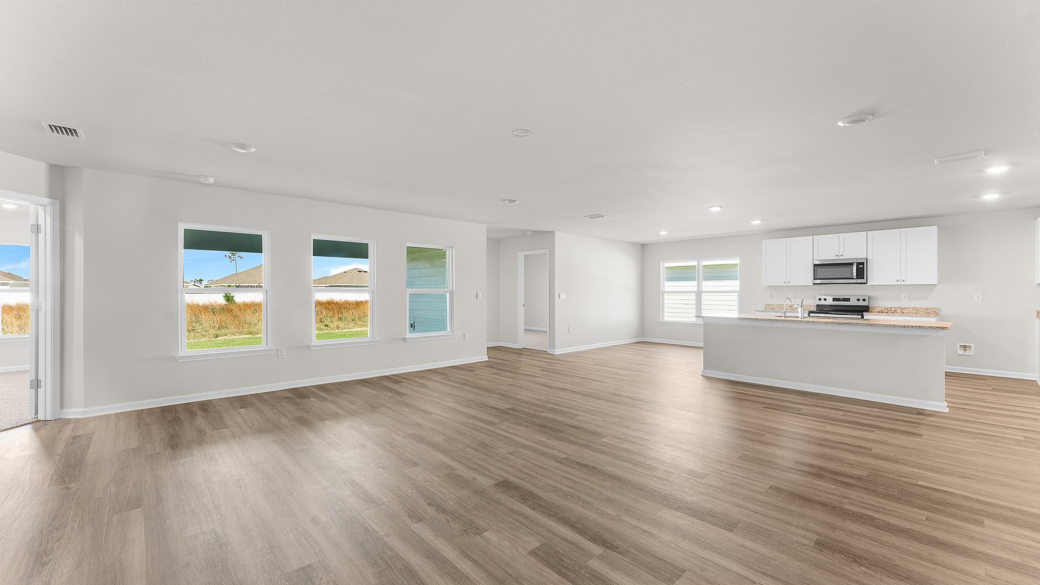 Open Living room with EVP flooring and kitchen.