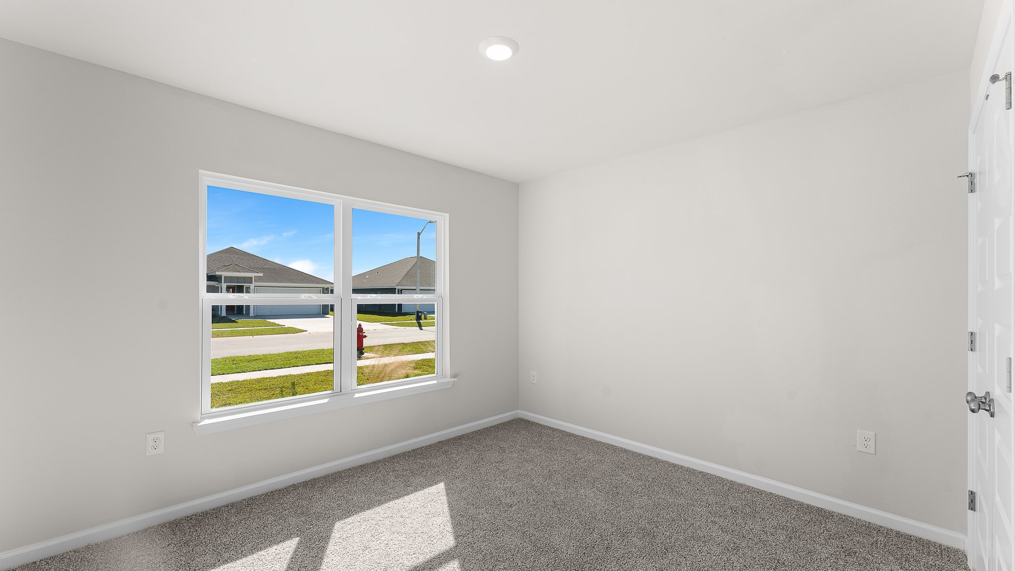 Bedroom with carpet floors and two windows.