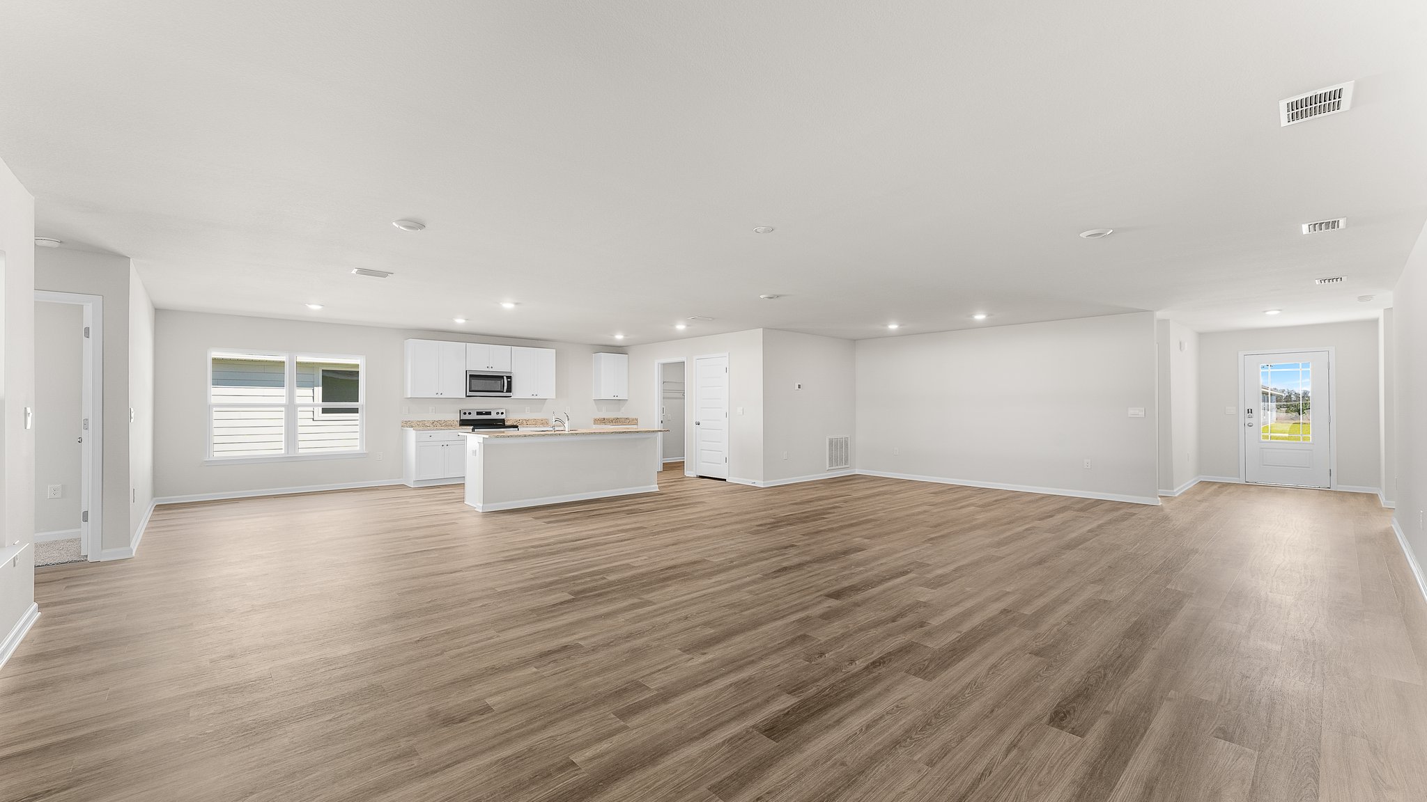 Open Living room with EVP flooring and kitchen.