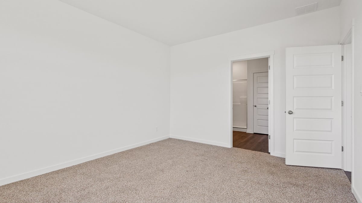 Bedroom with carpet and a bathroom and closet.