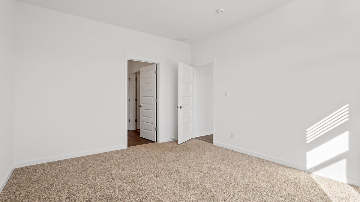 Bedroom with carpet and a bathroom and closet.