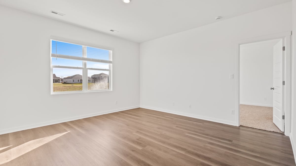 Living area with hard wood floors and a big window.