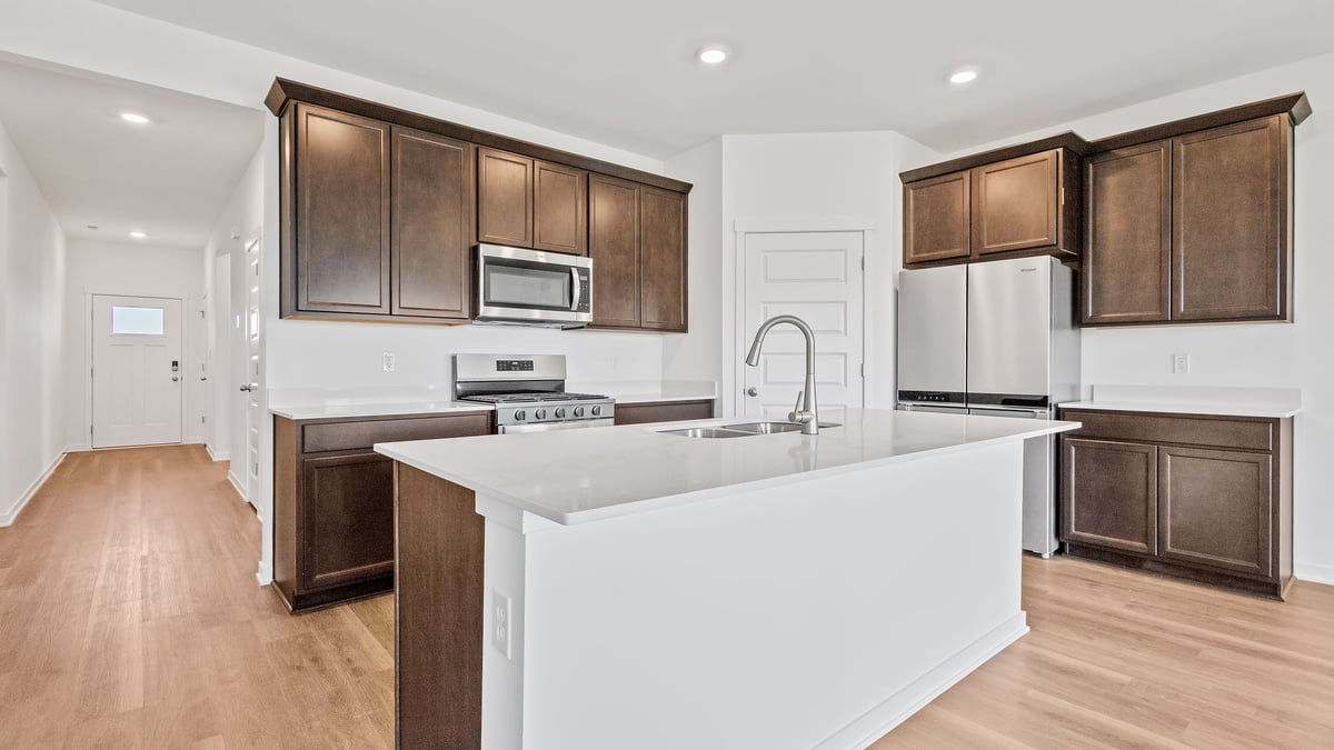 Kitchen with brown cabinets and hard wood floors.