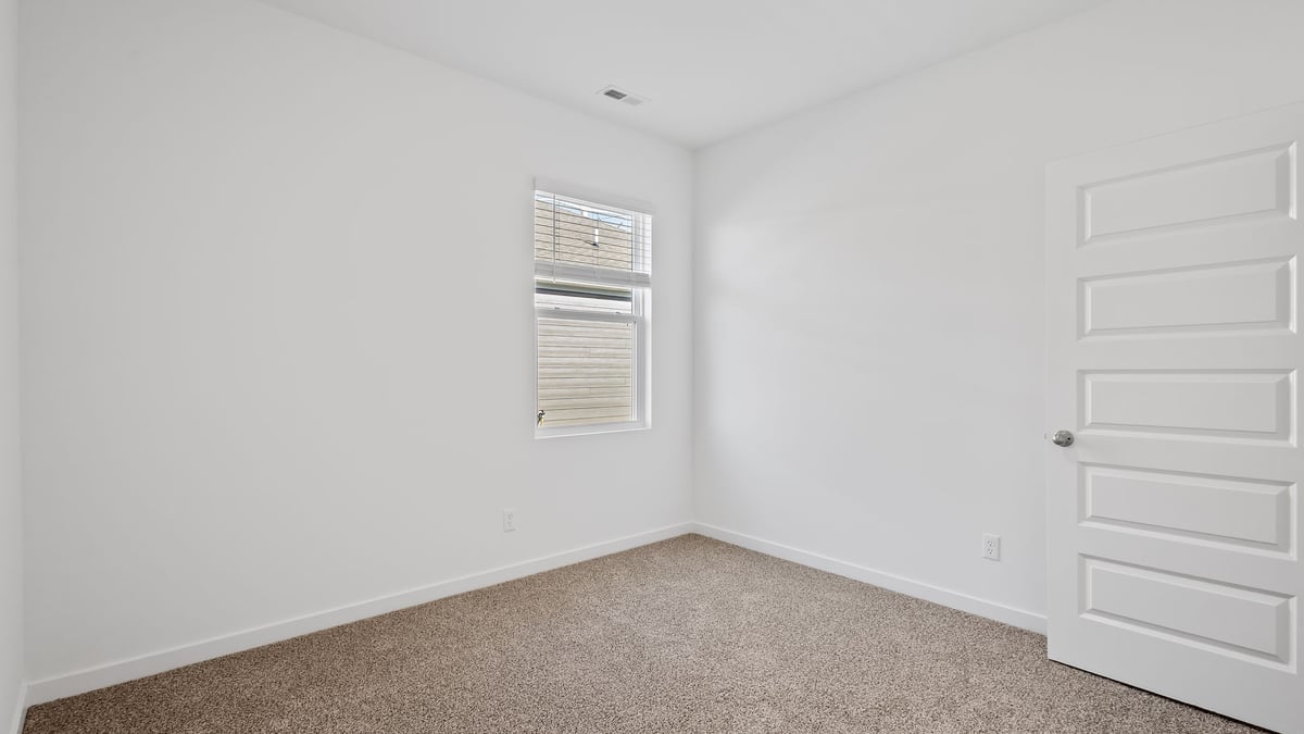 Bedroom with carpet and a window.