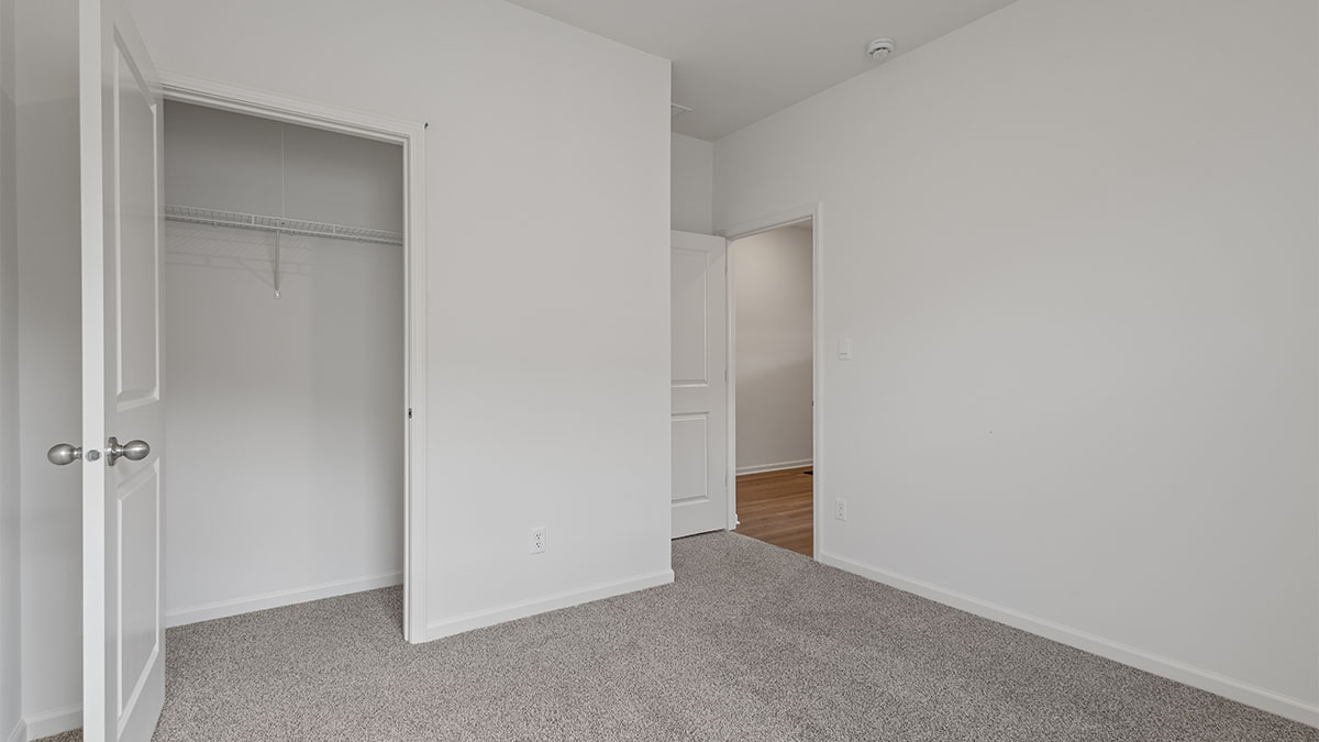 Bedroom with carpeted floors and a closet.