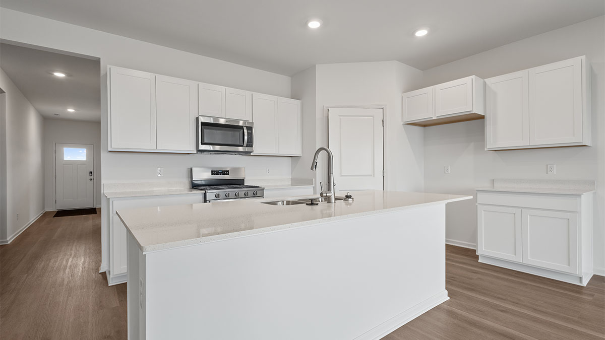 Kitchen with white cabinetry with a hard wood floors.