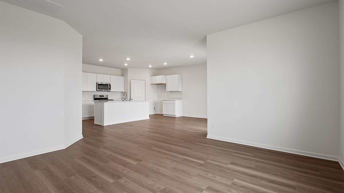 Living area viewing the kitchen with hard wood floors.