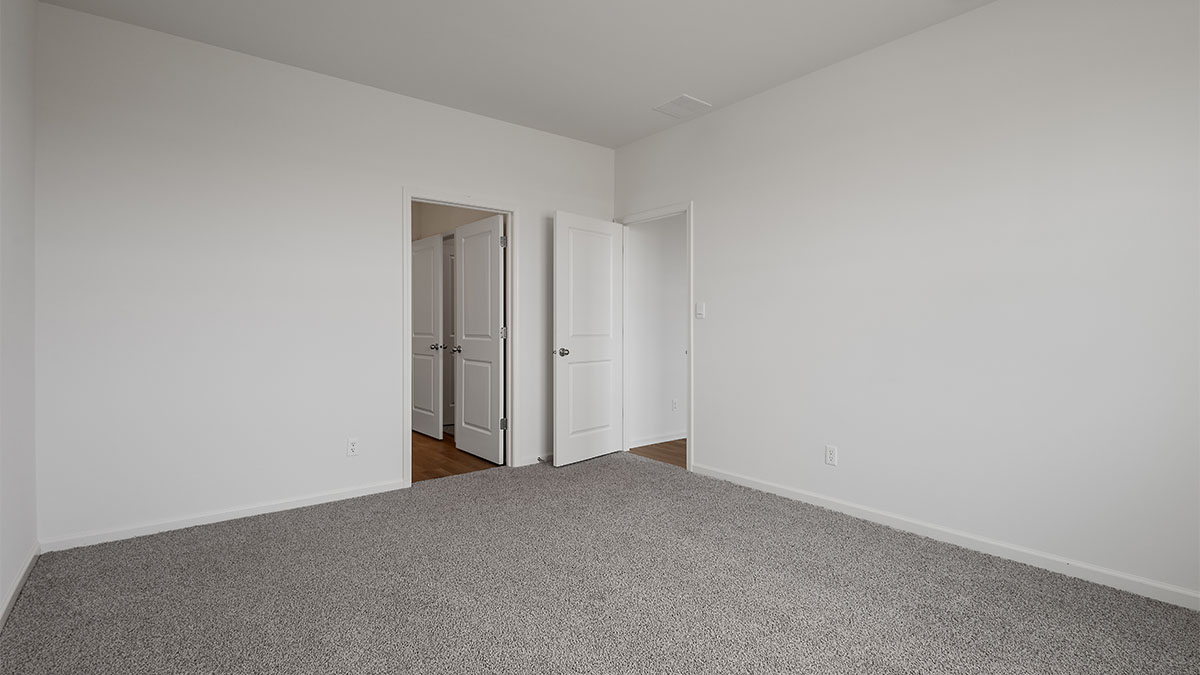 Primary bedroom with carpeted floors.