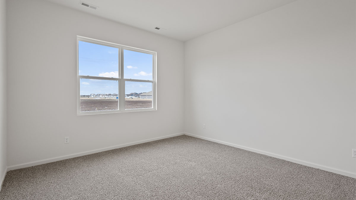 Bedroom with carpeted floors and a big window.