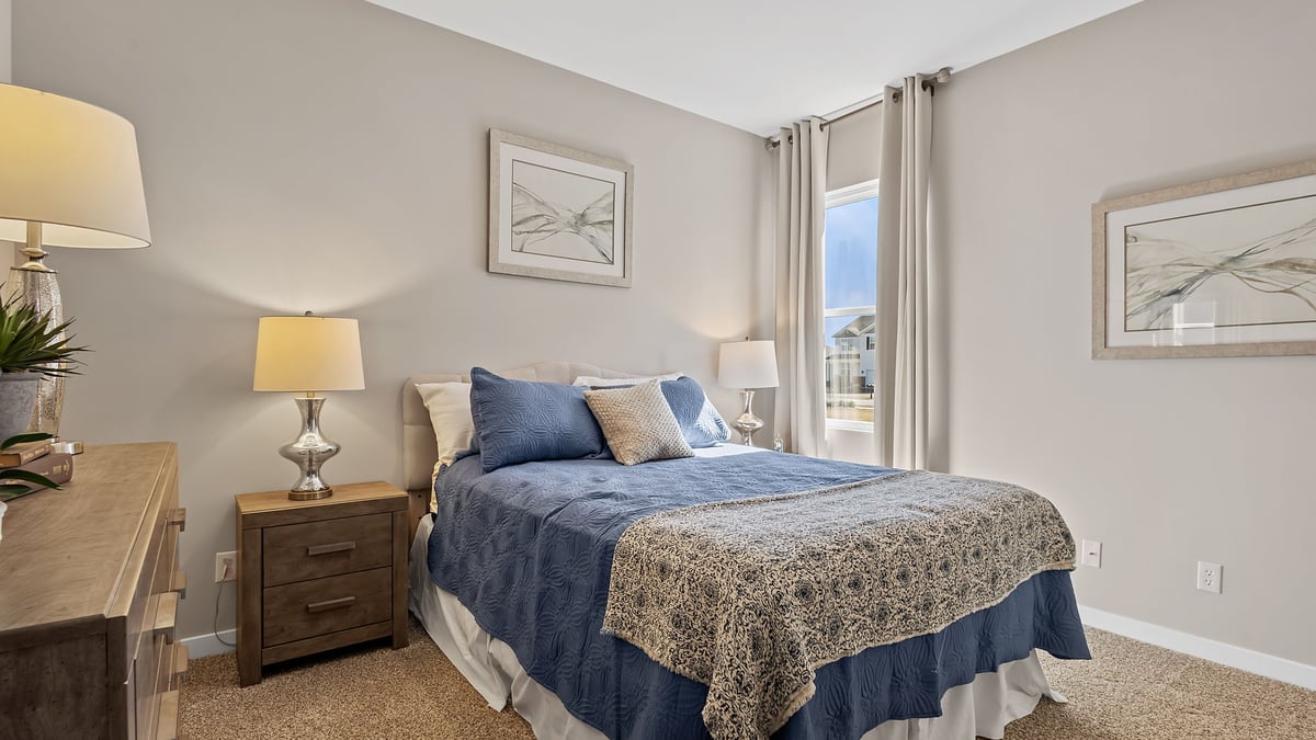 Bedroom with one side window and carpeted floors.